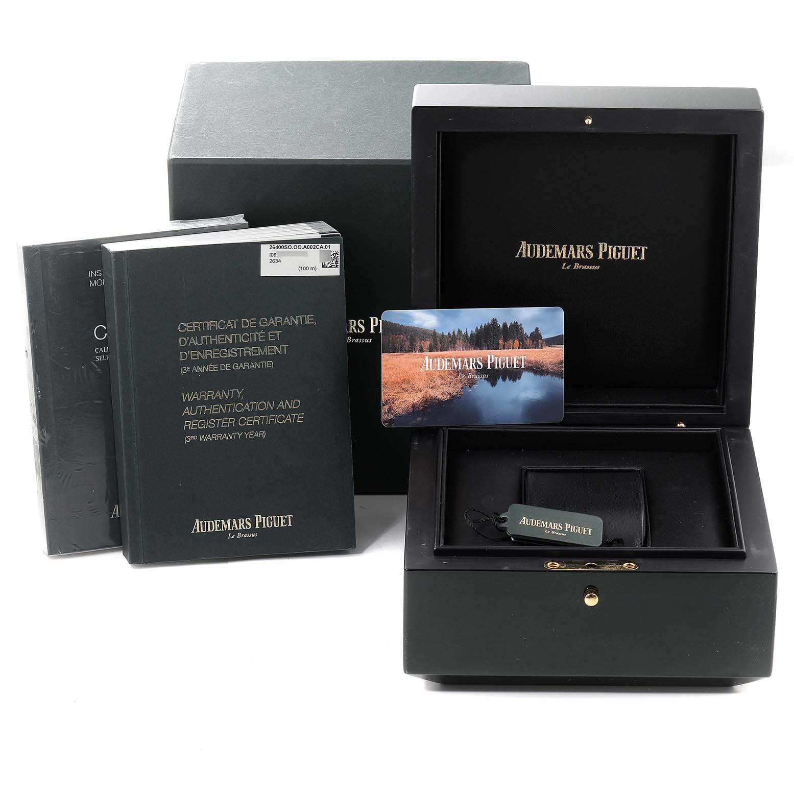 The image shows packaging, a presentation box, booklets, and a warranty/authentication card for the Royal Oak Offshore model by Audemars Piguet.