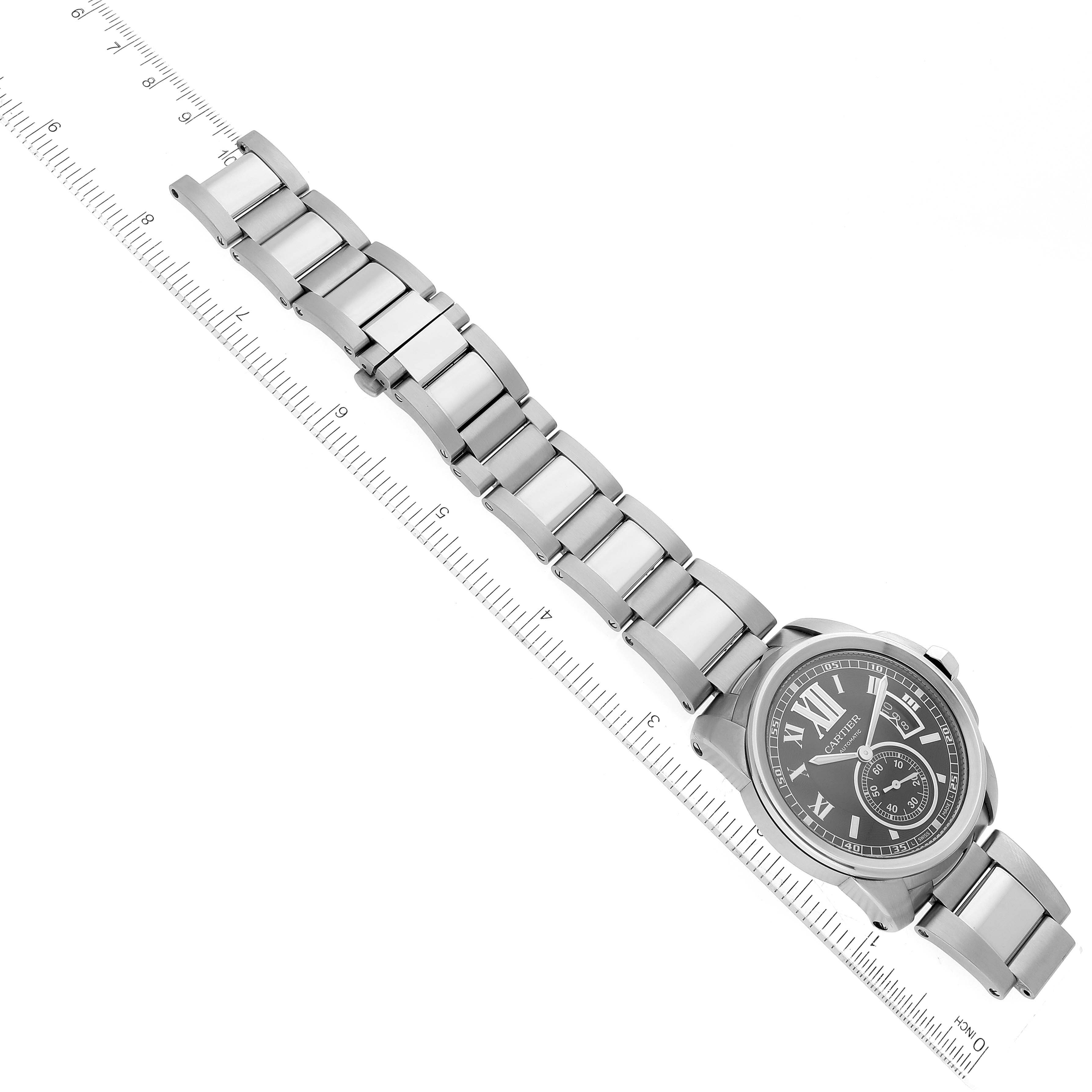 The image shows a top view of a Calibre de Cartier watch by Cartier, highlighting the face and entire metal bracelet with a measuring ruler.