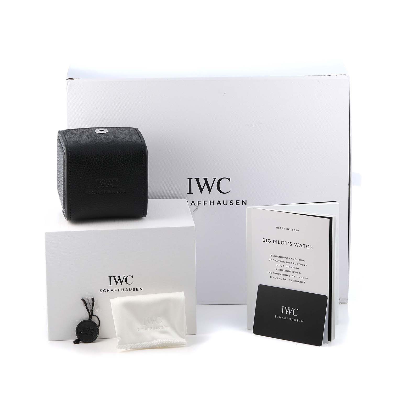 The image shows the IWC Pilot IW388106 Men's Ceramic Black Dial watch packaging, including a box, booklet, warranty card, and cleaning cloth.