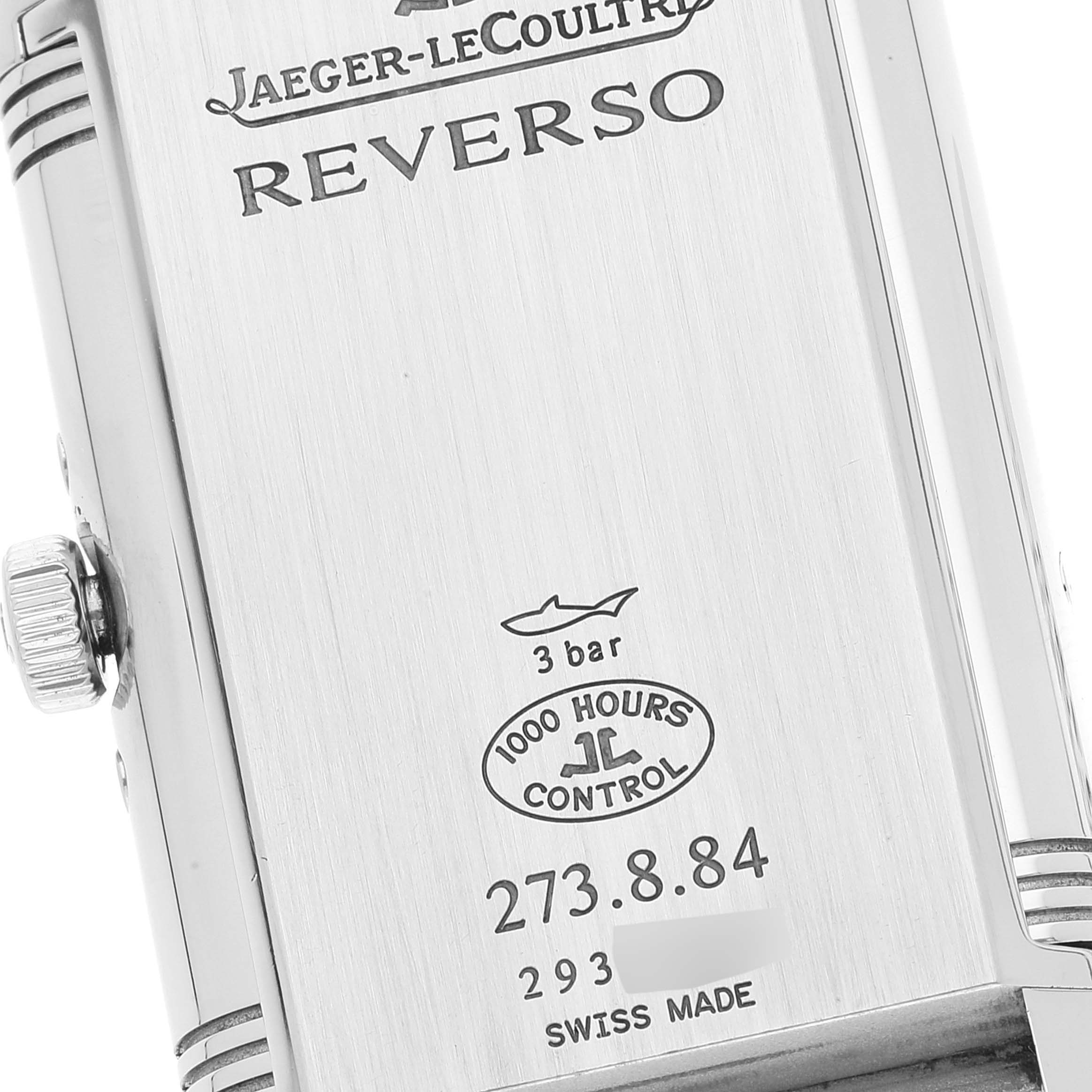 The close-up image shows the back side of the Jaeger-LeCoultre Reverso watch case and crown with engraved details.