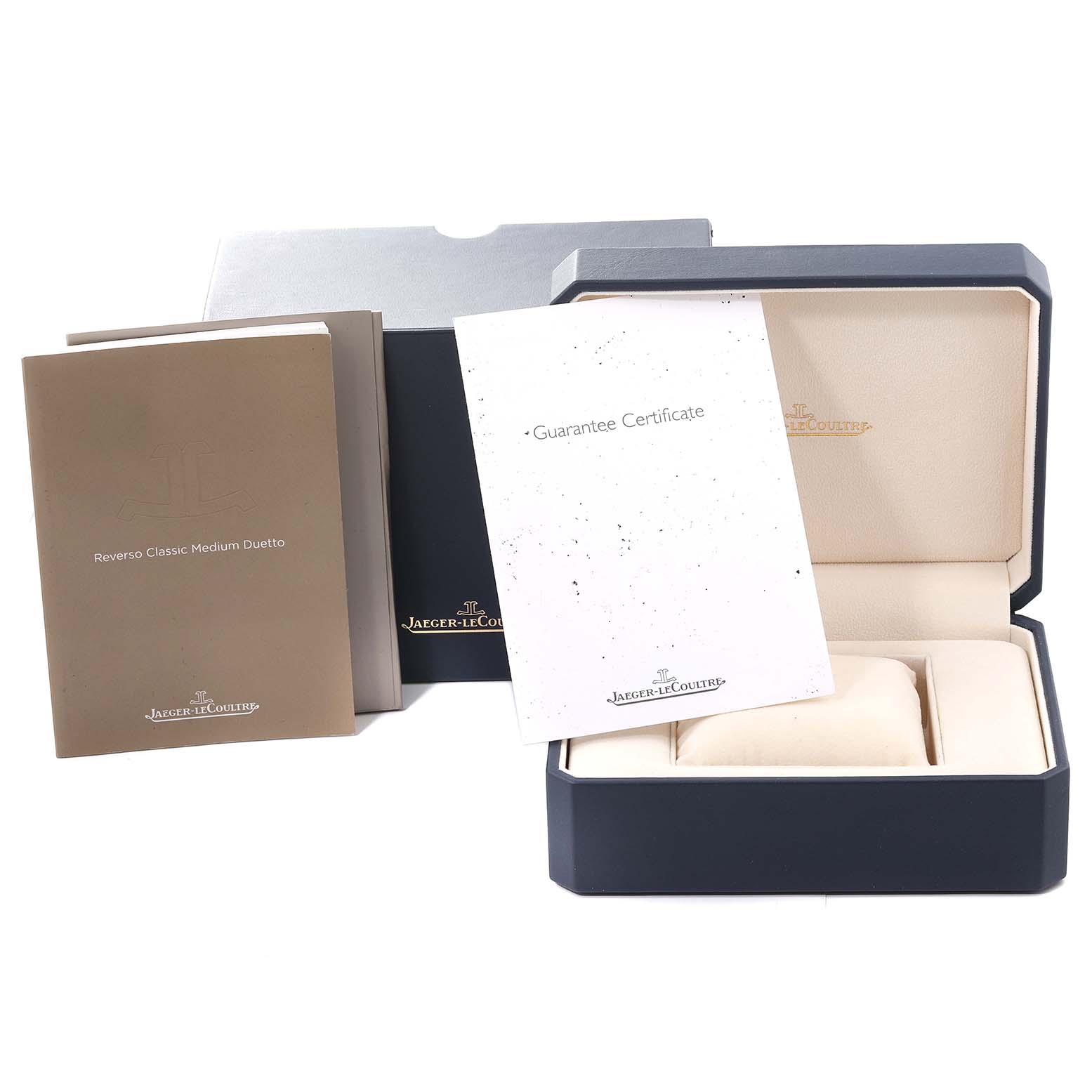 The image shows the packaging, guarantee certificate, and manual for a Jaeger-LeCoultre Reverso watch.