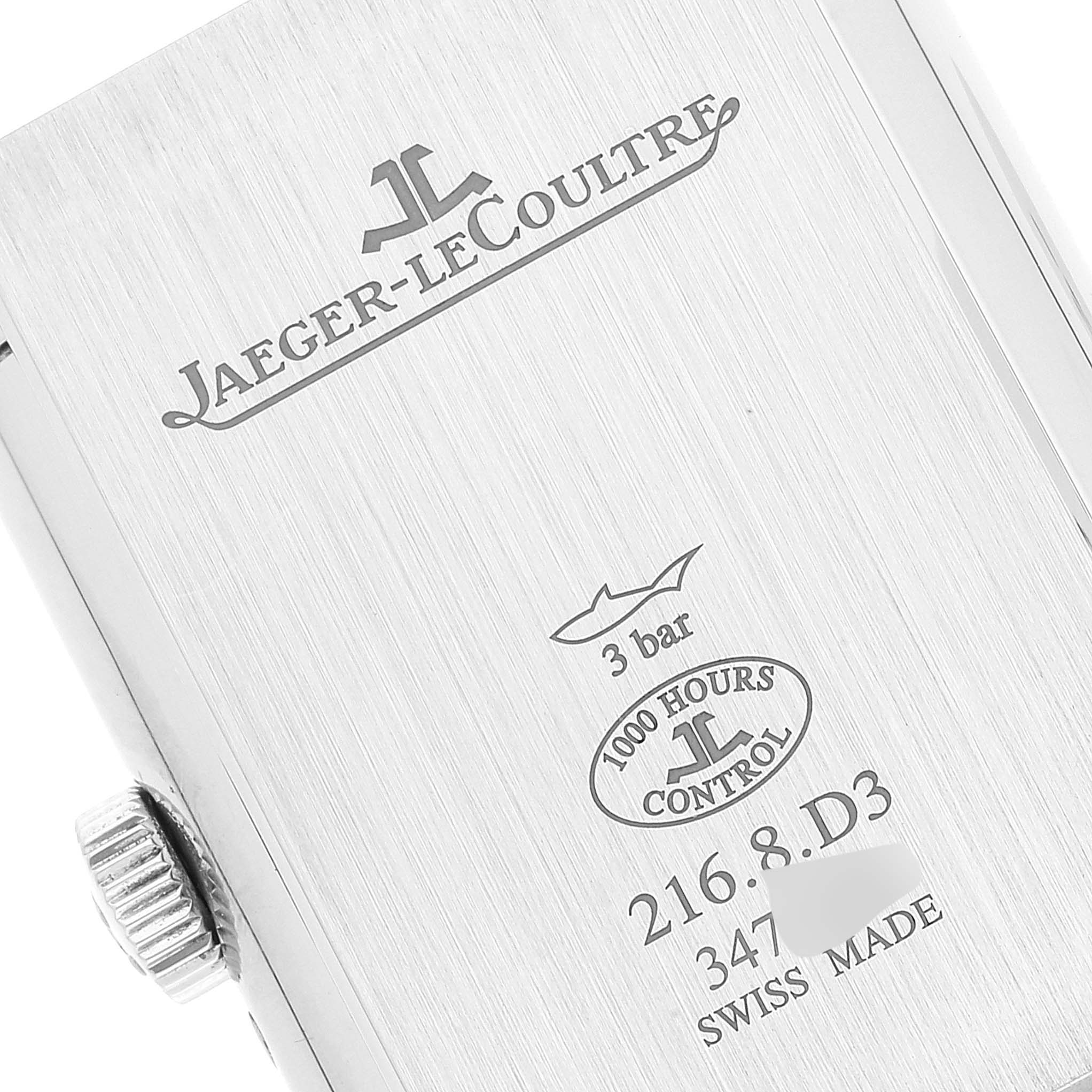 The image shows the back case of a Jaeger-LeCoultre Reverso watch at a close-up angle, featuring brand engravings and the crown.