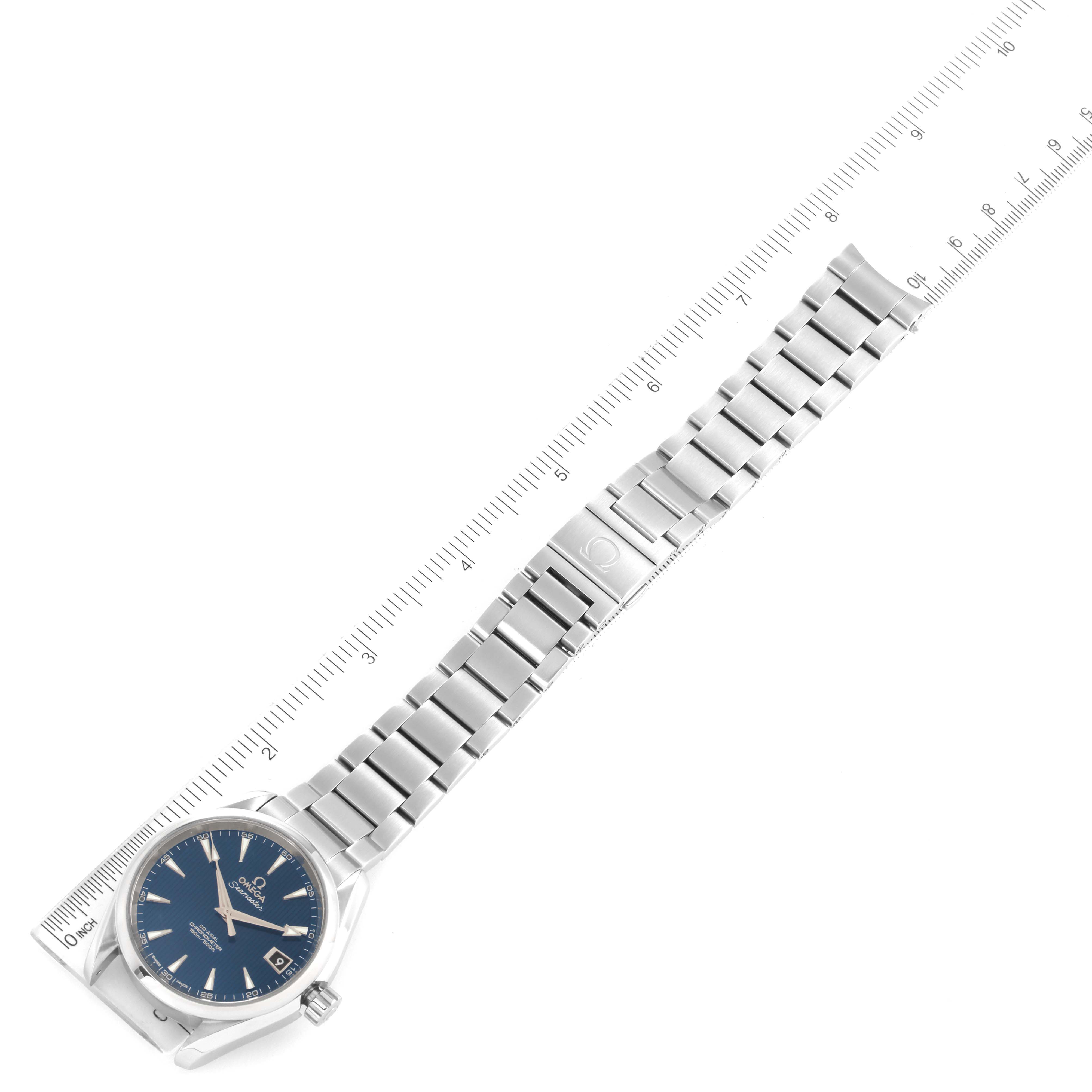 The image shows an Omega Aqua Terra 231.10.39.21.03.001 Men
s Stainless Steel Blue Dial 231.10.39.21.03.001 Men
s Stainless Steel Blue Dial watch laid flat, with a blue dial and metal bracelet next to a ruler for scale.