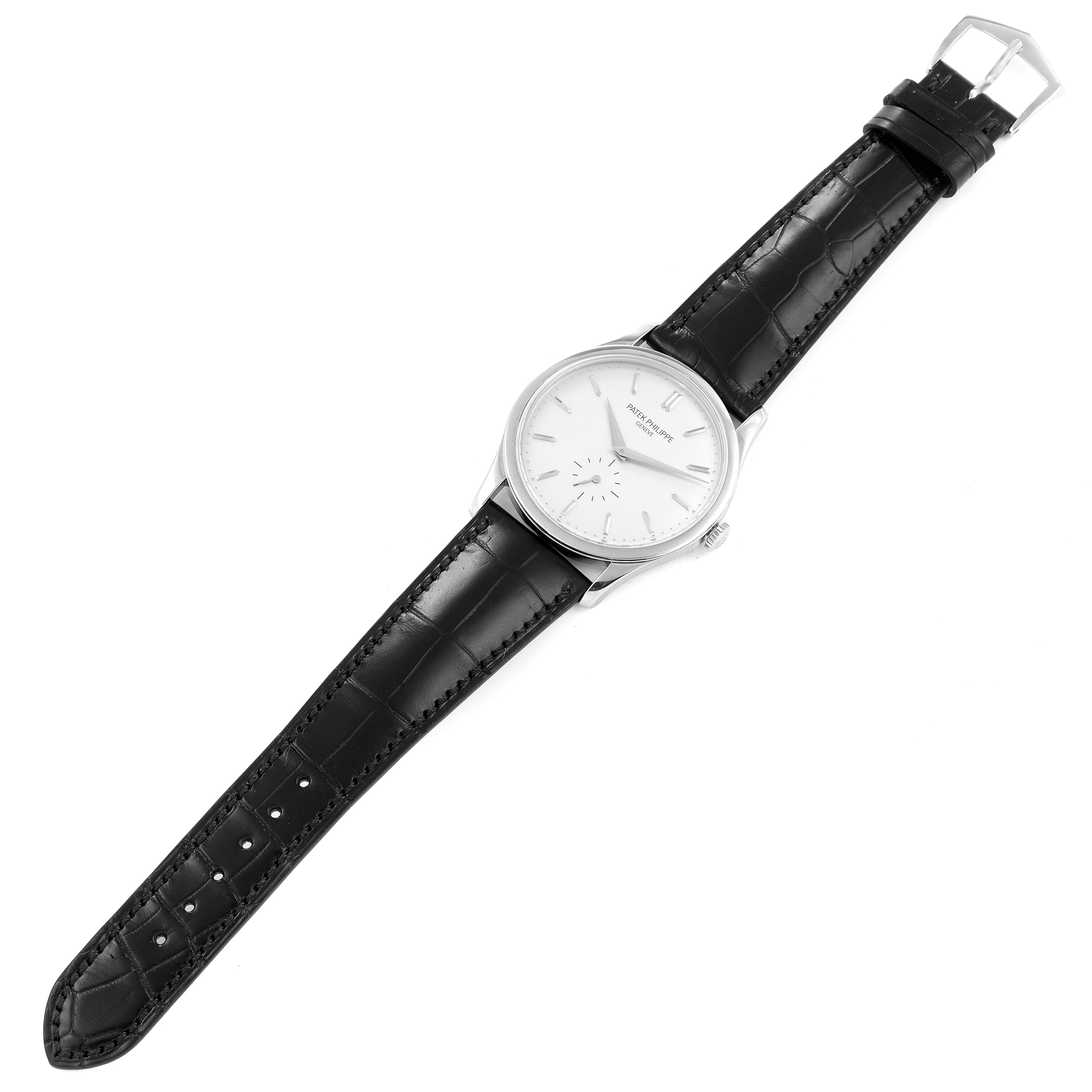 The image shows a top view of the Patek Philippe Calatrava 5196G Men's White Gold Silver Dial 5196G Men's White Gold Silver Dial watch, displaying its face, hands, case, and leather strap.