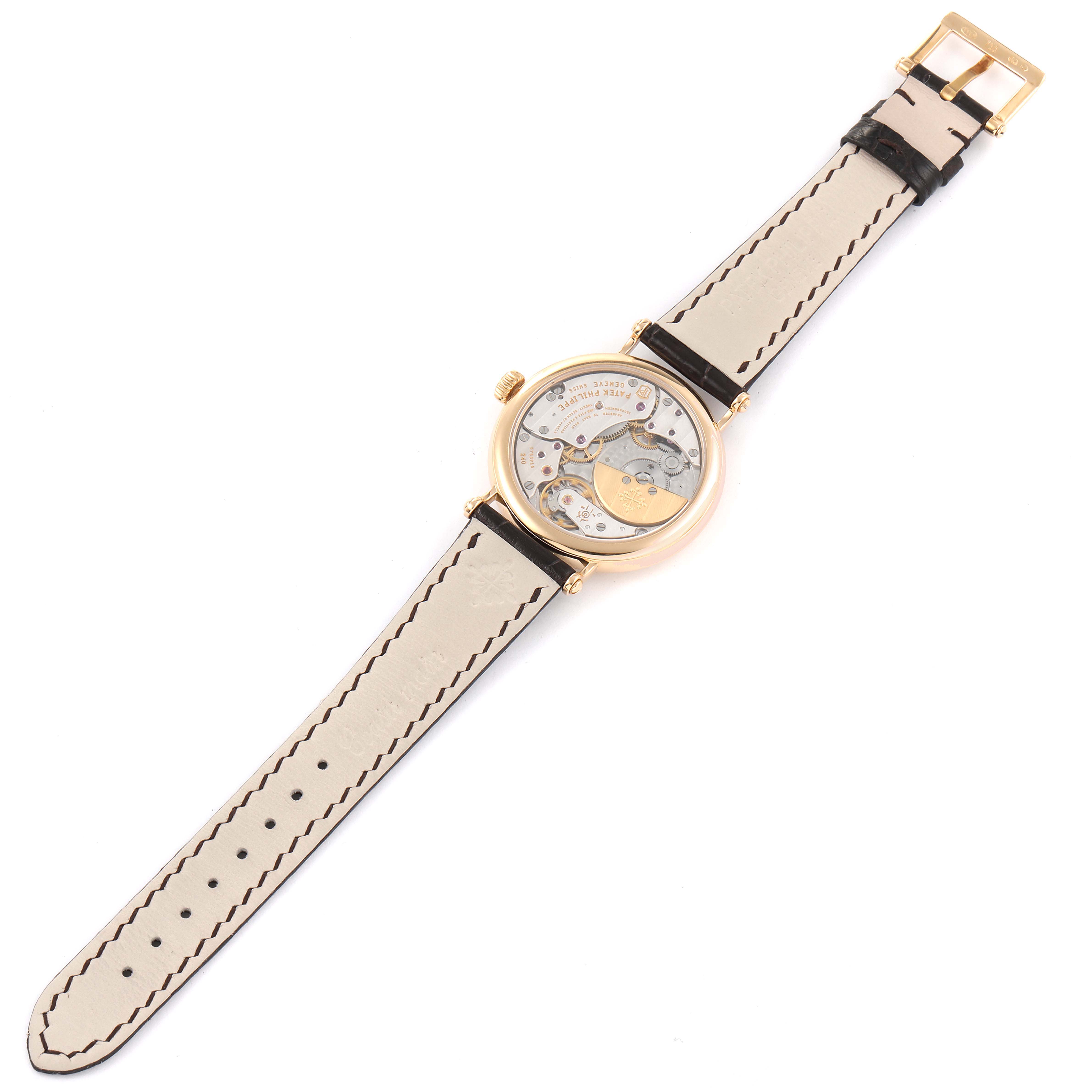 This image shows the back view of a Patek Philippe Calatrava 7200R Men
s Rose Gold Silver Dial 7200R Men
s Rose Gold Silver Dial watch, displaying its movement and leather strap.