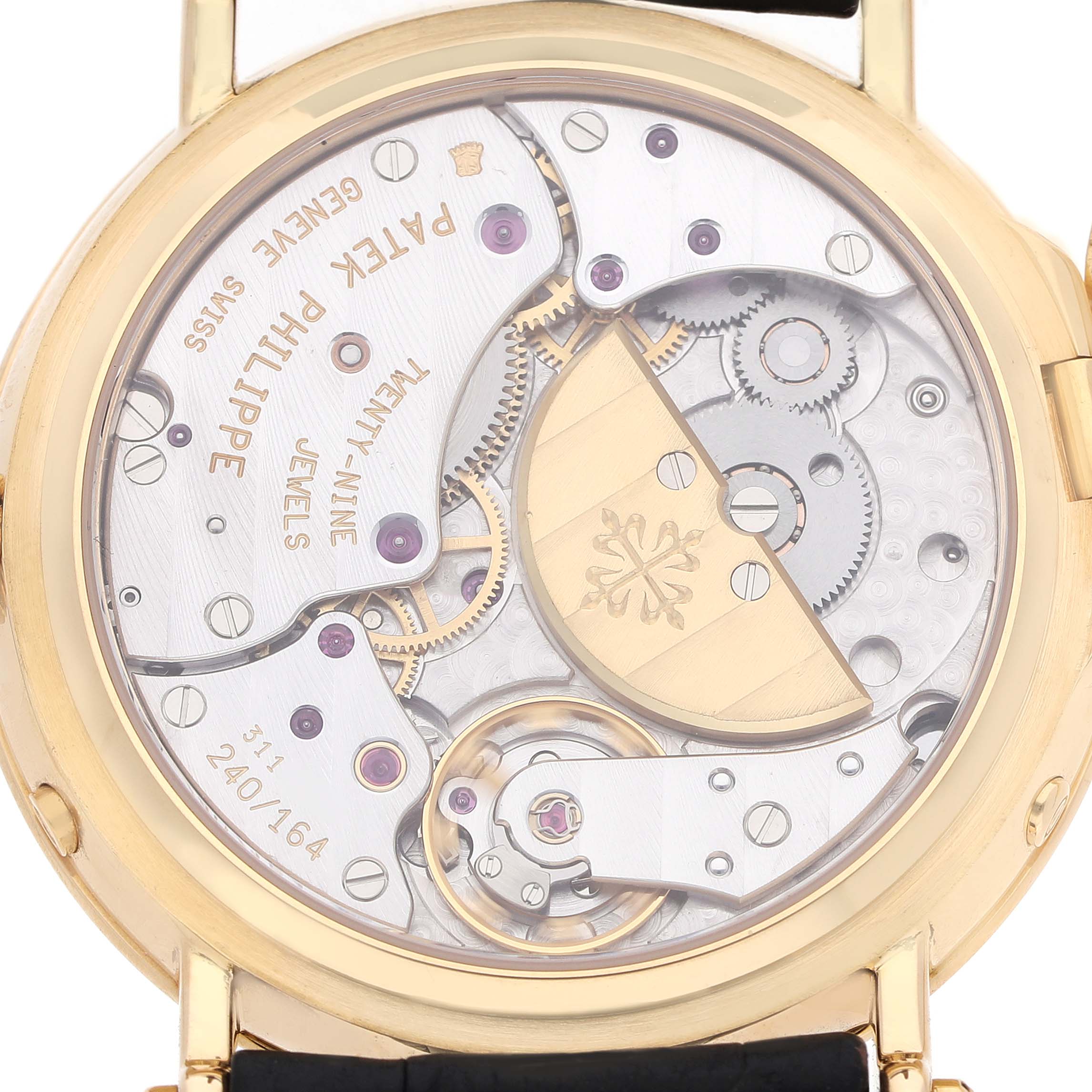 The image shows the back view of a Patek Philippe Complications 5054 Men's Yellow Gold White Dial watch, highlighting the intricate movement and components.