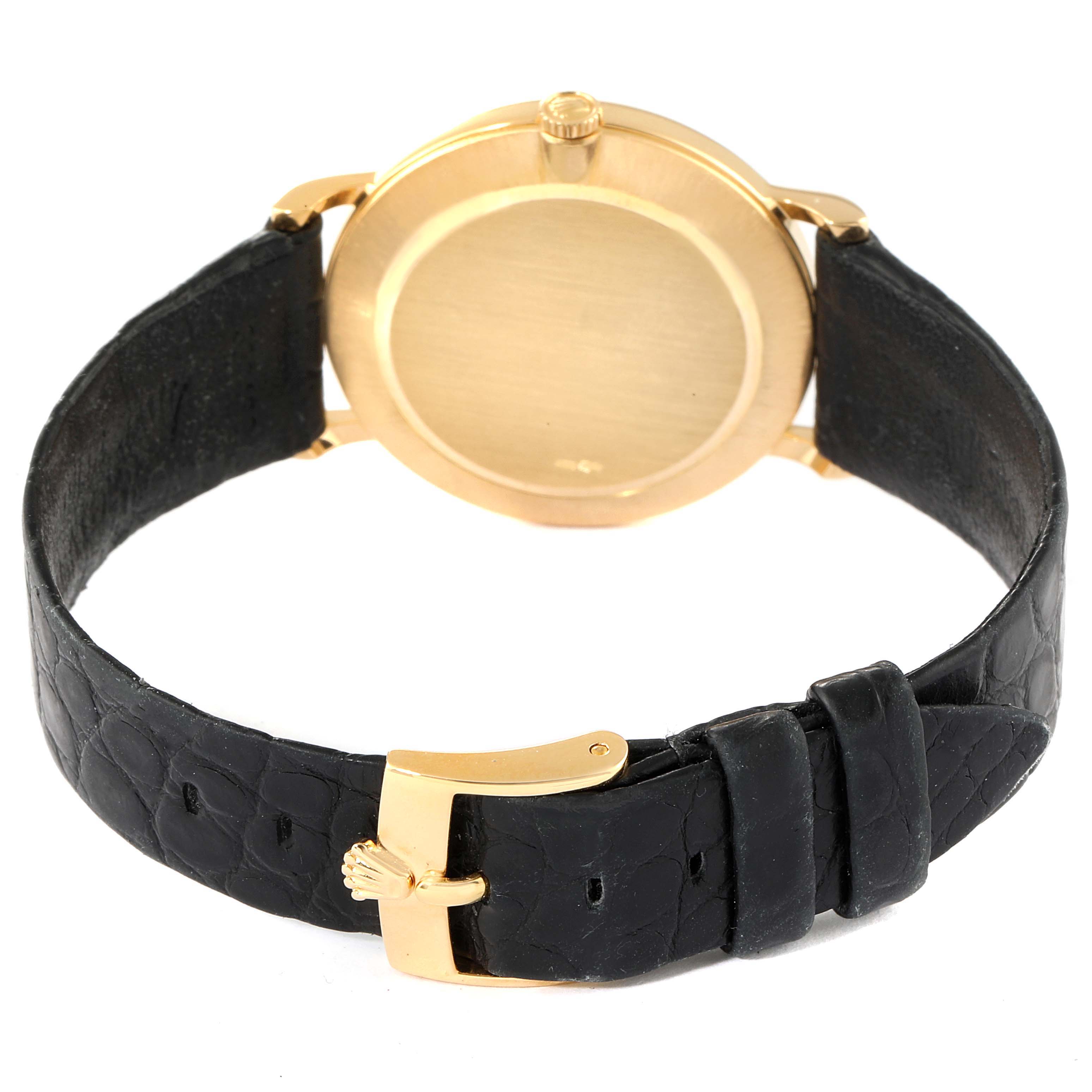 The image shows the back view of a Rolex Cellini 5112 Men's Yellow Gold Beige Dial 5112 Men's Yellow Gold Beige Dial watch, highlighting its gold casing and black leather strap with a gold buckle.