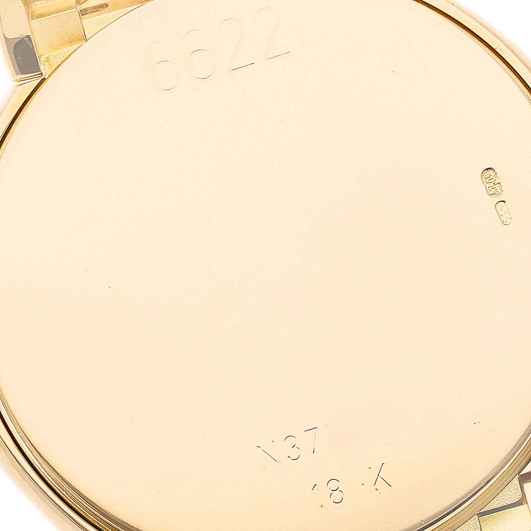 The image shows the gold case back of a Rolex Cellini 6622 Men
s Yellow Gold White Dial 6622 Men
s Yellow Gold White Dial watch at a close-up angle, highlighting engraved reference numbers.