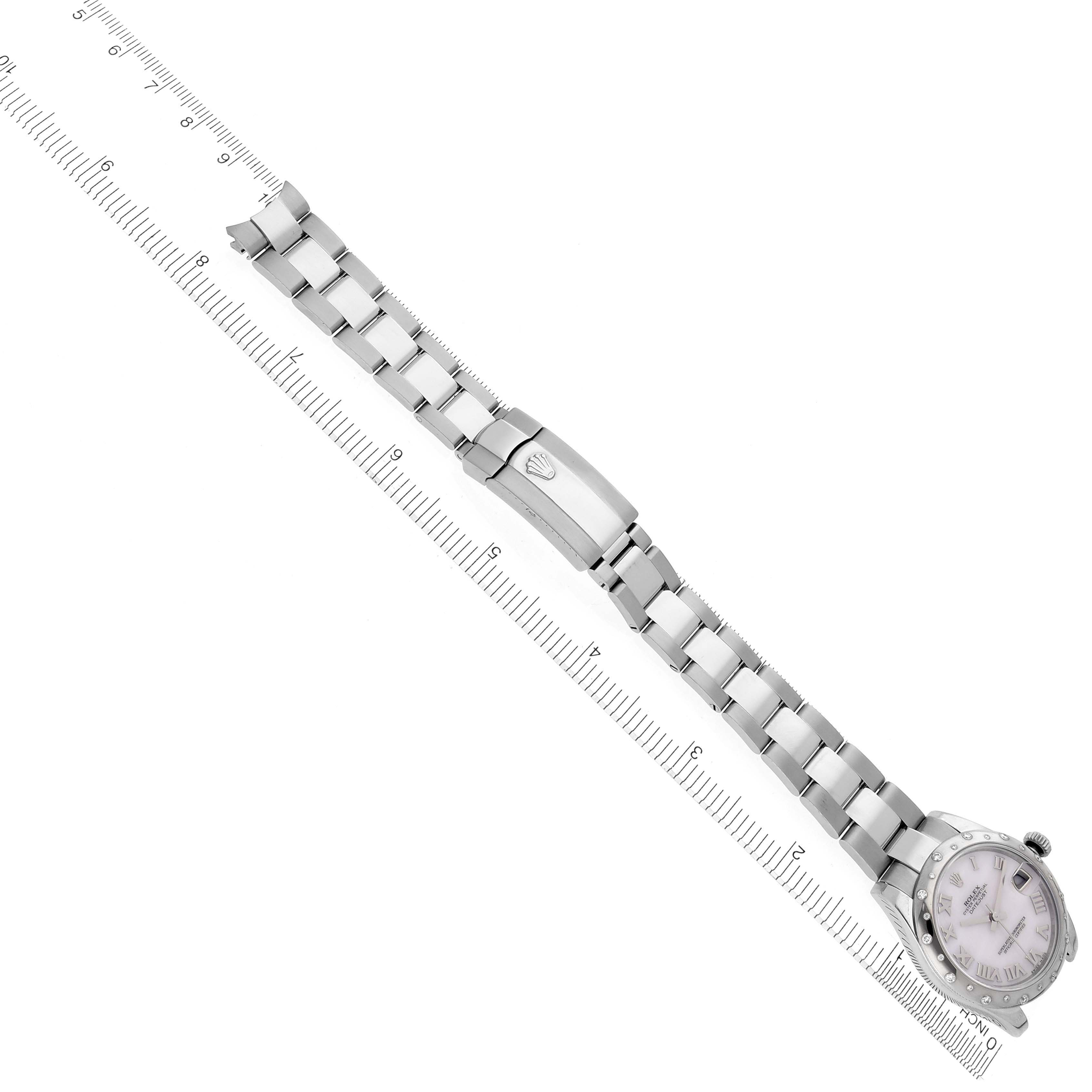 The Rolex Mid-Size 178344 Women's Stainless Steel Mother of Pearl Dial 178344 Women's Stainless Steel Mother of Pearl Dial watch is angled diagonally, showing the face and full bracelet alongside a ruler for scale.