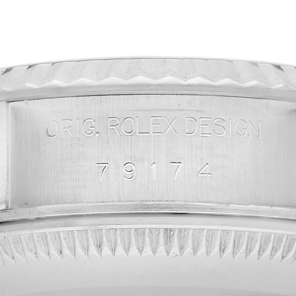 The image shows the side engraving of a Rolex Datejust 79174 Women's Stainless Steel Black Dial 79174 Women's Stainless Steel Black Dial bezel with text "ORIG. ROLEX DESIGN" and numbers.