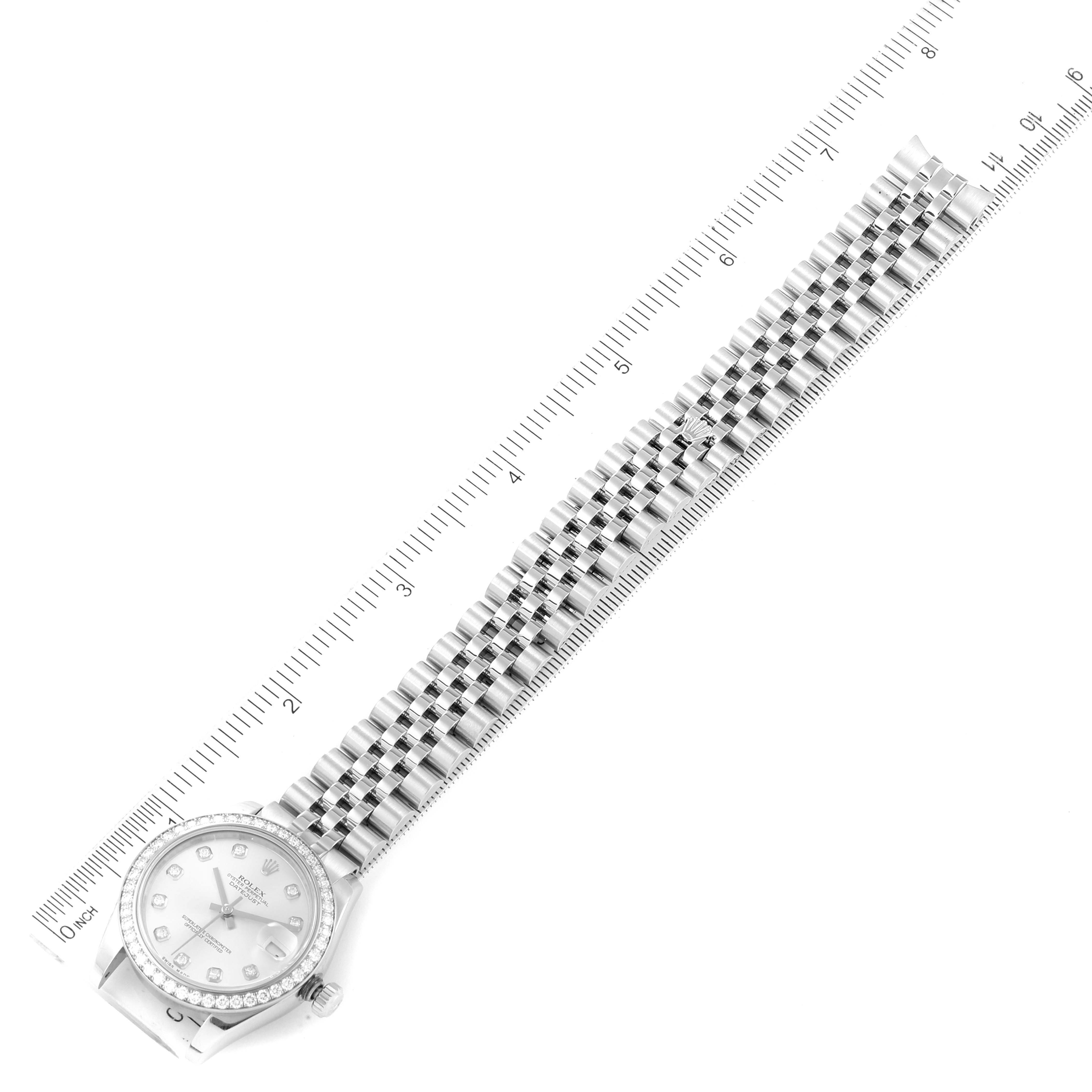 This image shows a Mid-Size Rolex watch laid flat next to a ruler, displaying the entire face and bracelet.