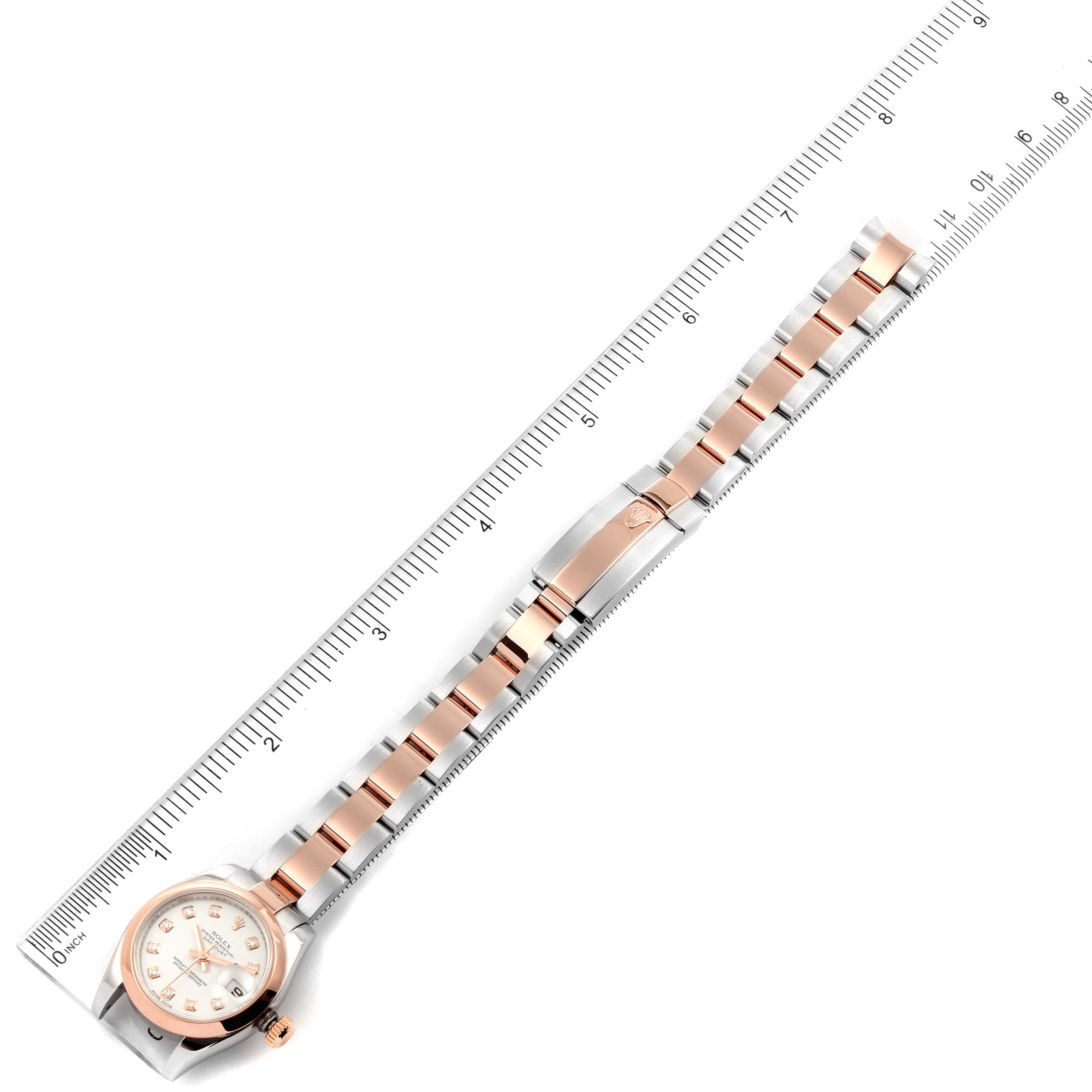 The image shows a Rolex Datejust 179161 Women's Steel and Gold (two tone) White Dial 179161 Women's Steel and Gold (two tone) White Dial watch in a top-down view, highlighting the face, clasp, and full bracelet against a measuring ruler.