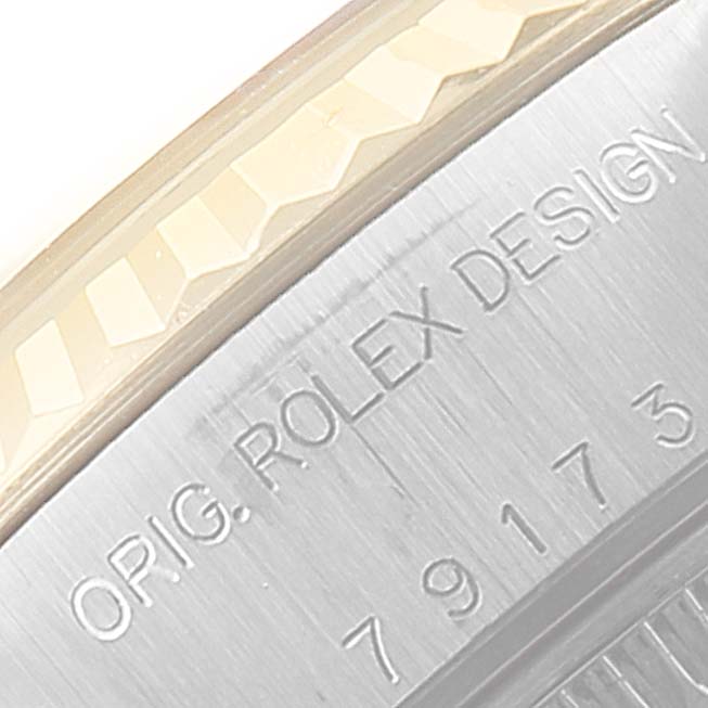 The image shows an up-close view of the bezel and engraved case edge of a Rolex Datejust 79173 Women's Steel and Gold (two tone) Black Dial 79173 Women's Steel and Gold (two tone) Black Dial watch.