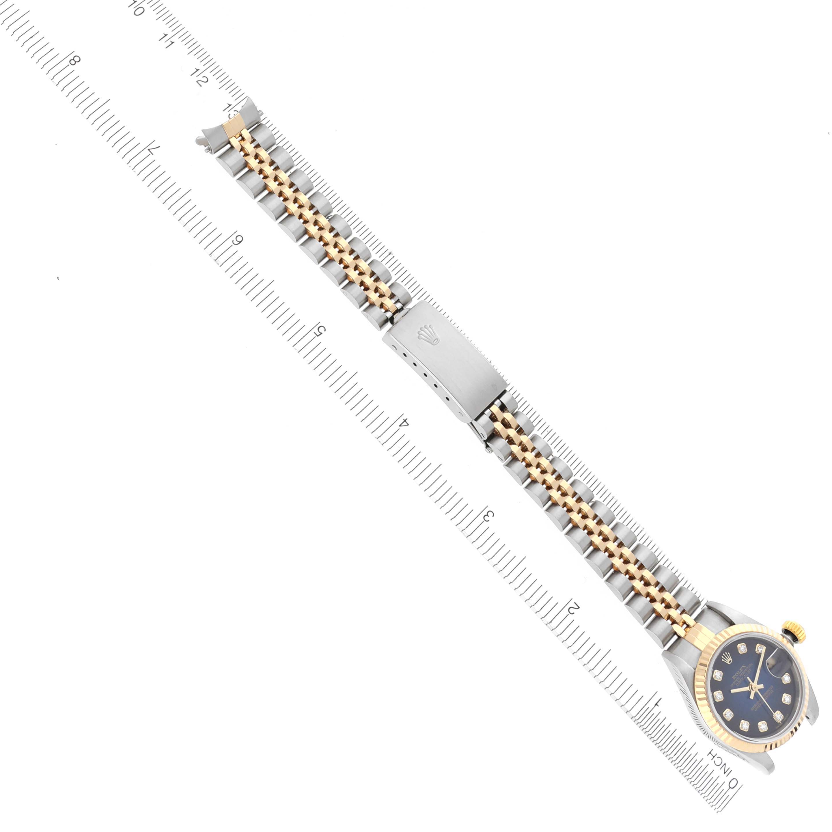 The Rolex Datejust 79173 Women's Steel and Gold (two tone) Blue Dial 79173 Women's Steel and Gold (two tone) Blue Dial watch is shown from a top view, displaying the bracelet, clasp, and face with a scale for measurement.