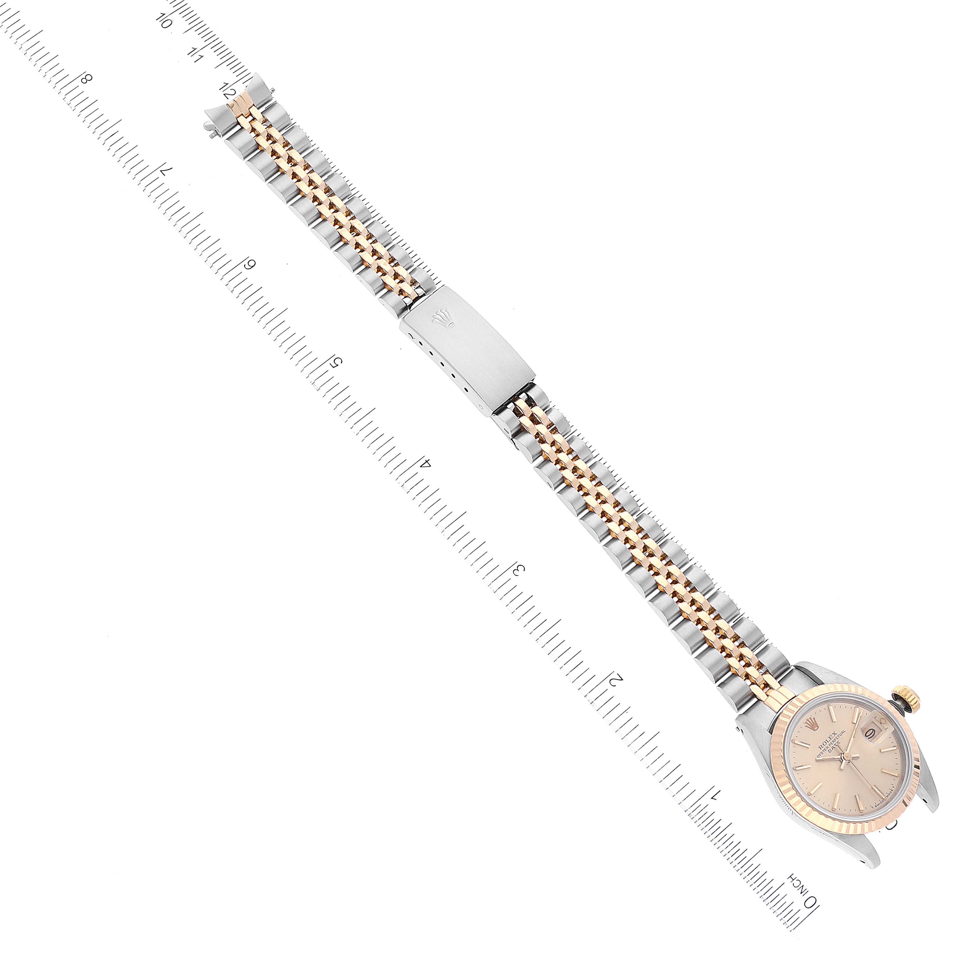 The image shows a Rolex Datejust 69173 Women's Steel and Gold (two tone) Champagne Dial 69173 Women's Steel and Gold (two tone) Champagne Dial watch at an overhead angle, highlighting its face, bracelet, and clasp alongside a ruler for scale.