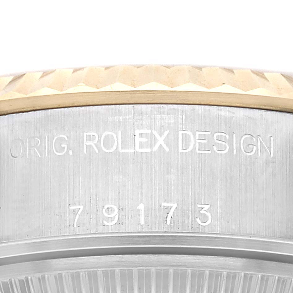 This close-up image shows the side of the casing and parts of the bezel of a Rolex Datejust 79173 Women's Steel and Gold (two tone) Champagne Dial 79173 Women's Steel and Gold (two tone) Champagne Dial watch, including the engraved model number.