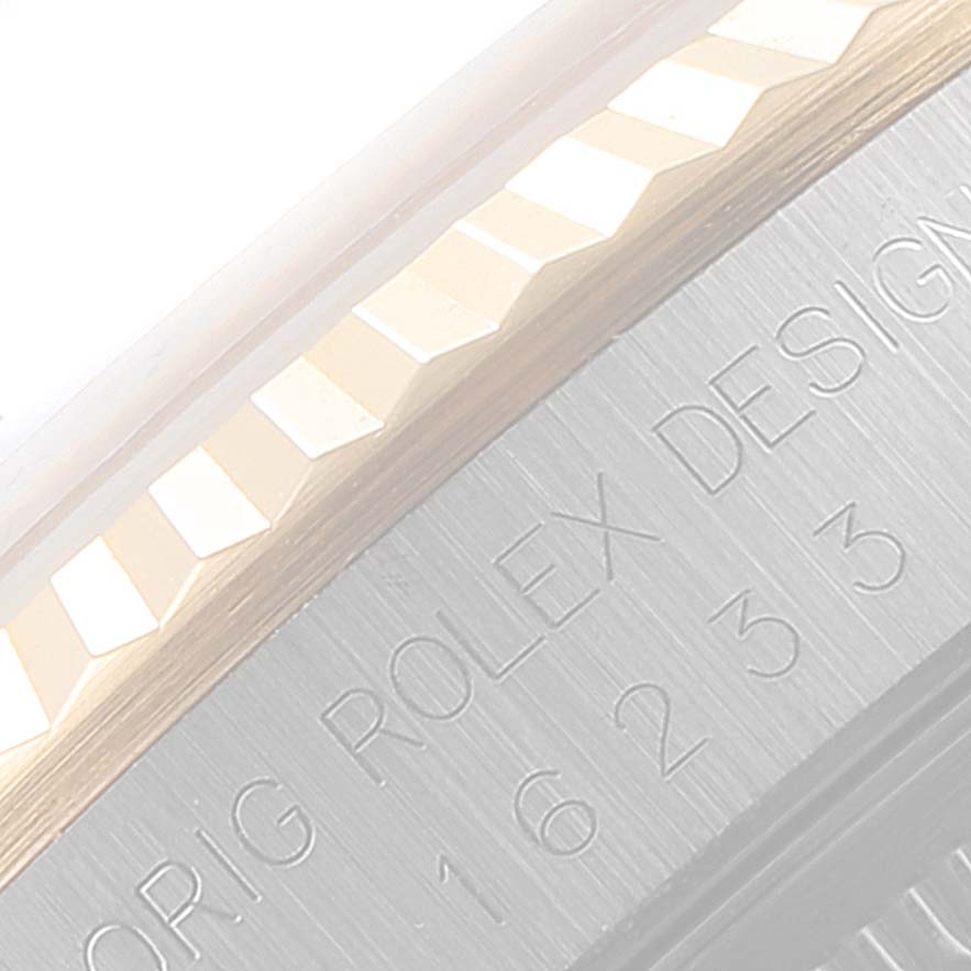 This close-up image shows the fluted bezel and part of the engraved text on the side of a Rolex Date 16233 Men's Steel and Gold (two tone) Champagne Dial 16233 Men's Steel and Gold (two tone) Champagne Dial model watch.