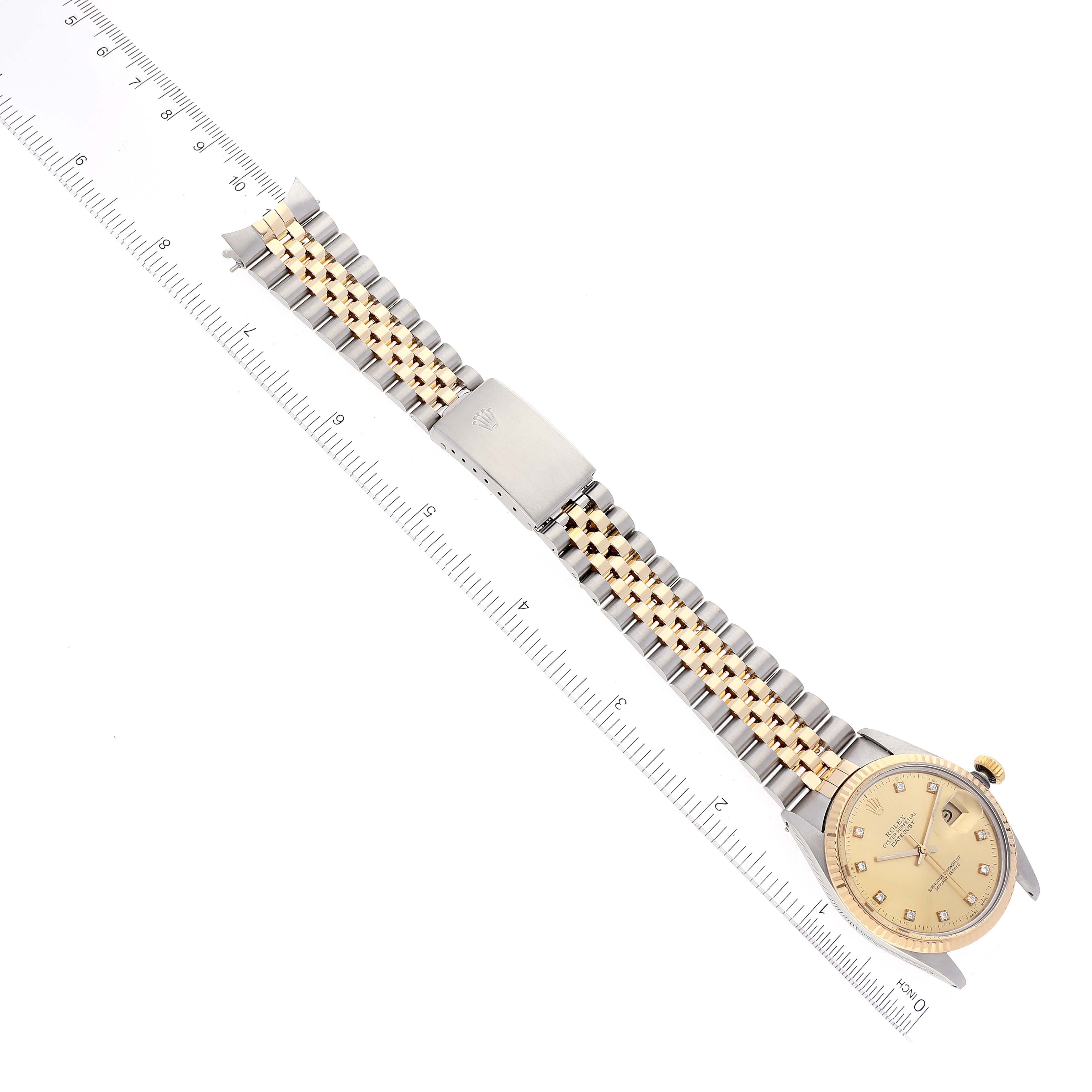 The image shows a Rolex Datejust 16013 Men's Steel and Gold (two tone) Champagne Dial 16013 Men's Steel and Gold (two tone) Champagne Dial watch laid flat from the dial side, along with its bracelet and clasp, next to a ruler for scale.