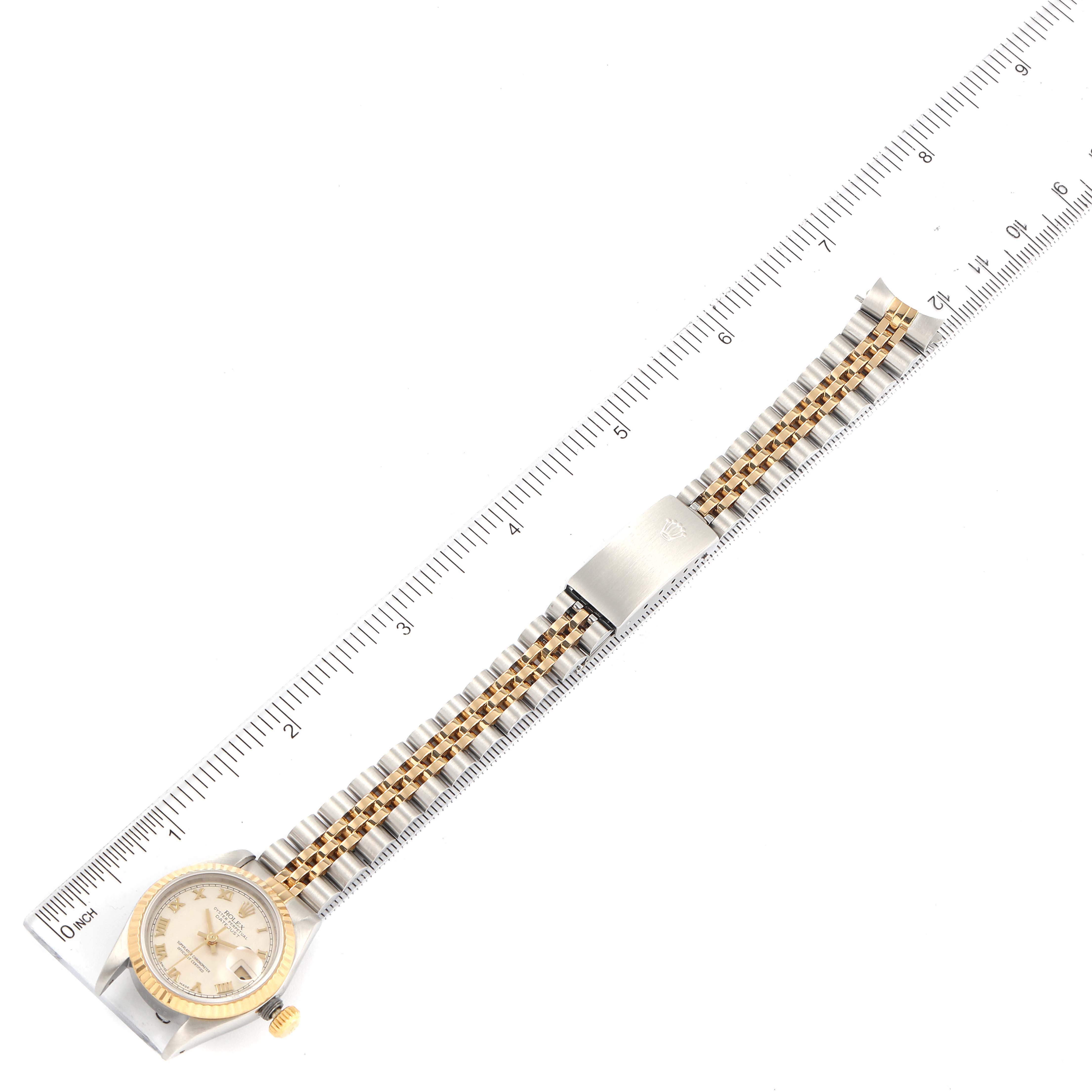 This image shows a full top view of a Rolex Datejust 69173 Women's Steel and Gold (two tone) Beige Dial 69173 Women's Steel and Gold (two tone) Beige Dial watch, featuring its face, bezel, and two-tone bracelet with a ruler for scale.