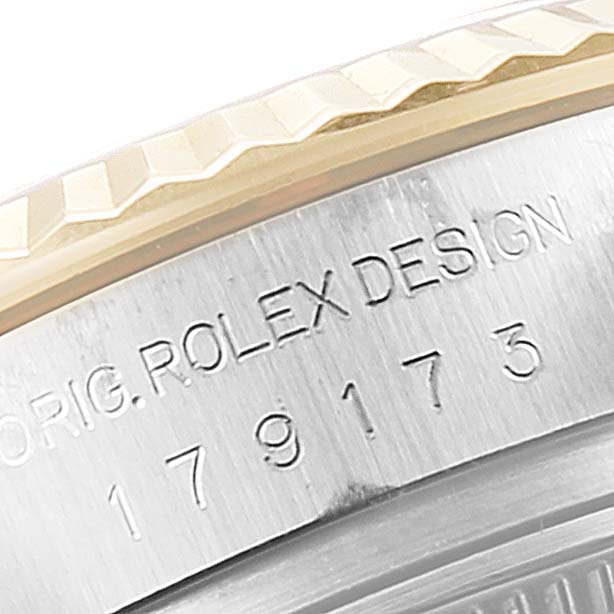 The image shows a close-up of the engraved design and serial number on the bezel of a Rolex Datejust 179173 Women
s Steel and Gold (two tone) Silver Dial 179173 Women
s Steel and Gold (two tone) Silver Dial.
