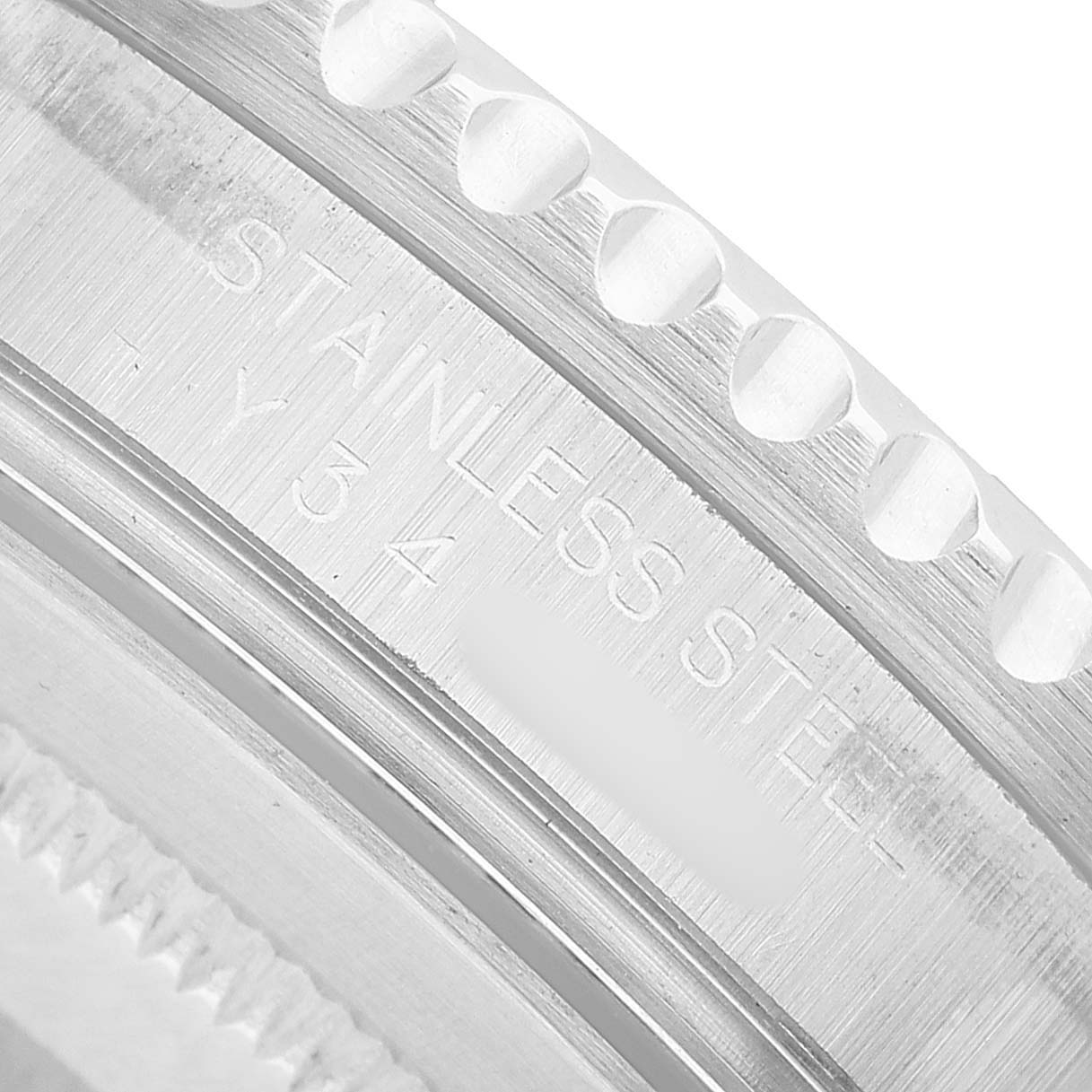 The image shows a close-up of the Rolex GMT-Master 16710 Men's Stainless Steel Black Dial's case side engraving, highlighting "Stainless Steel."