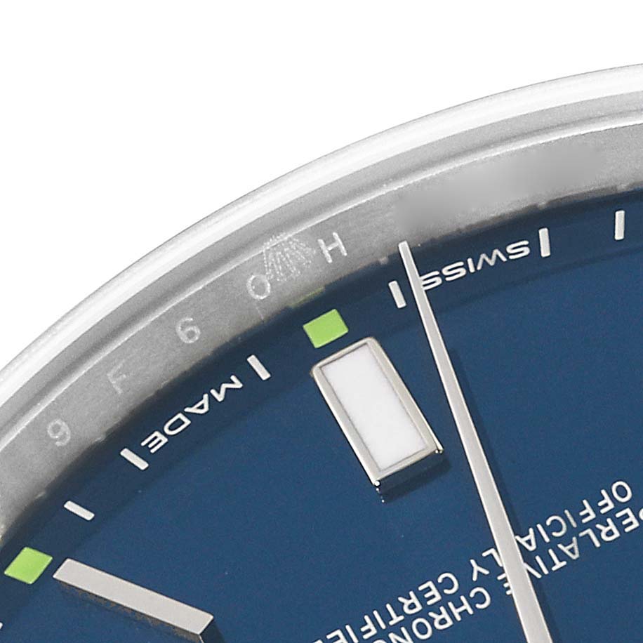 This is a close-up of the Rolex Oyster Perpetual 114300 Men
s Stainless Steel Blue Dial 114300 Men
s Stainless Steel Blue Dial watch, showing a segment of the blue dial, indices, and part of the hands.