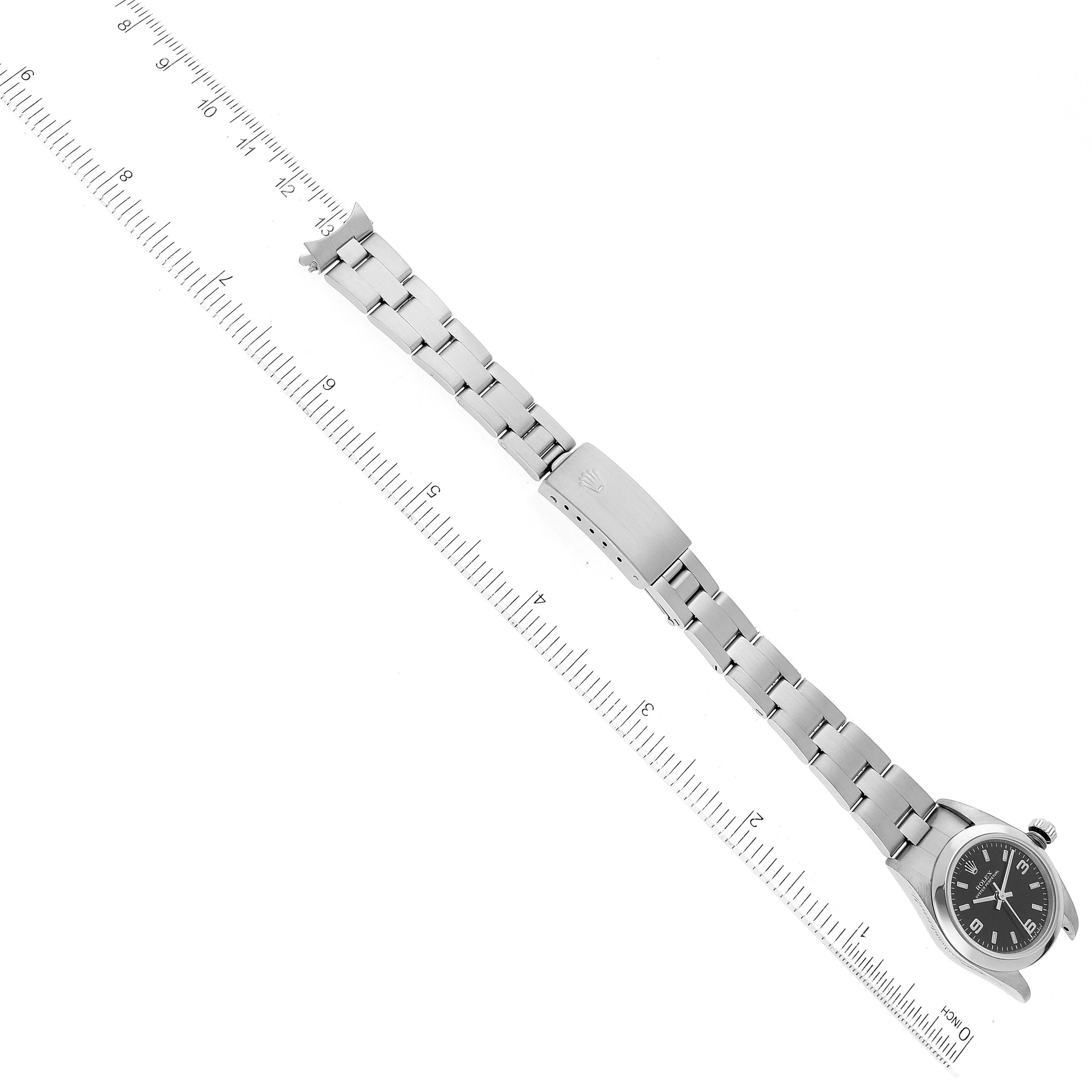 The image shows the front angle of a Rolex Oyster Perpetual 76080 Women's Stainless Steel Black Dial 76080 Women's Stainless Steel Black Dial watch, displaying its face, crown, and full bracelet with a ruler for scale.