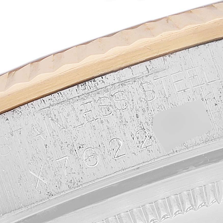 This image shows a close-up of the side rim of a Rolex Oyster Perpetual 14233 Men
s Steel and Gold (two tone) White Dial 14233 Men
s Steel and Gold (two tone) White Dial watch, highlighting the stainless steel and part of the serial number.