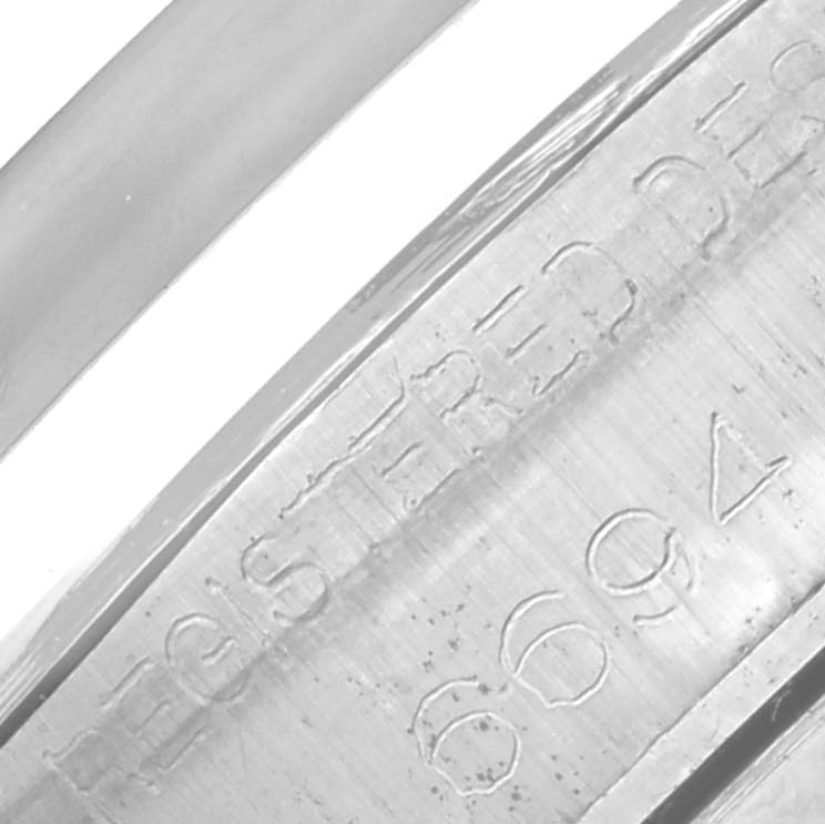 The image shows a close-up of the engraved side of a Rolex Date 6694 Men's Stainless Steel Black Dial 6694 Men's Stainless Steel Black Dial model watch case, featuring part of the serial number.