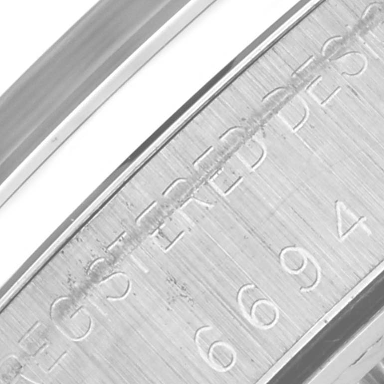 The image shows a close-up of the engraved side of a Rolex Date 6694 Men's Stainless Steel Silver Dial 6694 Men's Stainless Steel Silver Dial model watch case, focusing on the serial or reference numbers.