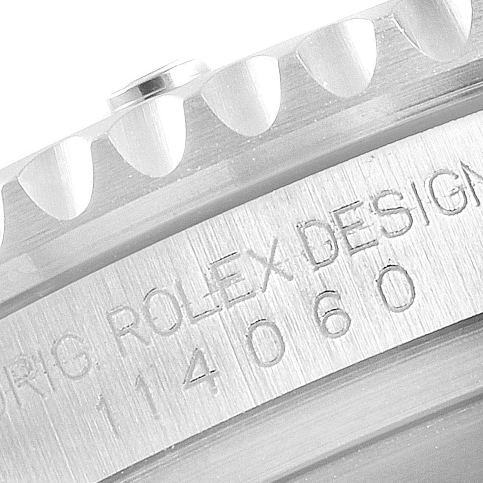 The image shows a close-up of the Rolex Submariner 114060 Men
s Stainless Steel Black Dial 114060 Men
s Stainless Steel Black Dial
s bezel and engraved model number on the case side.