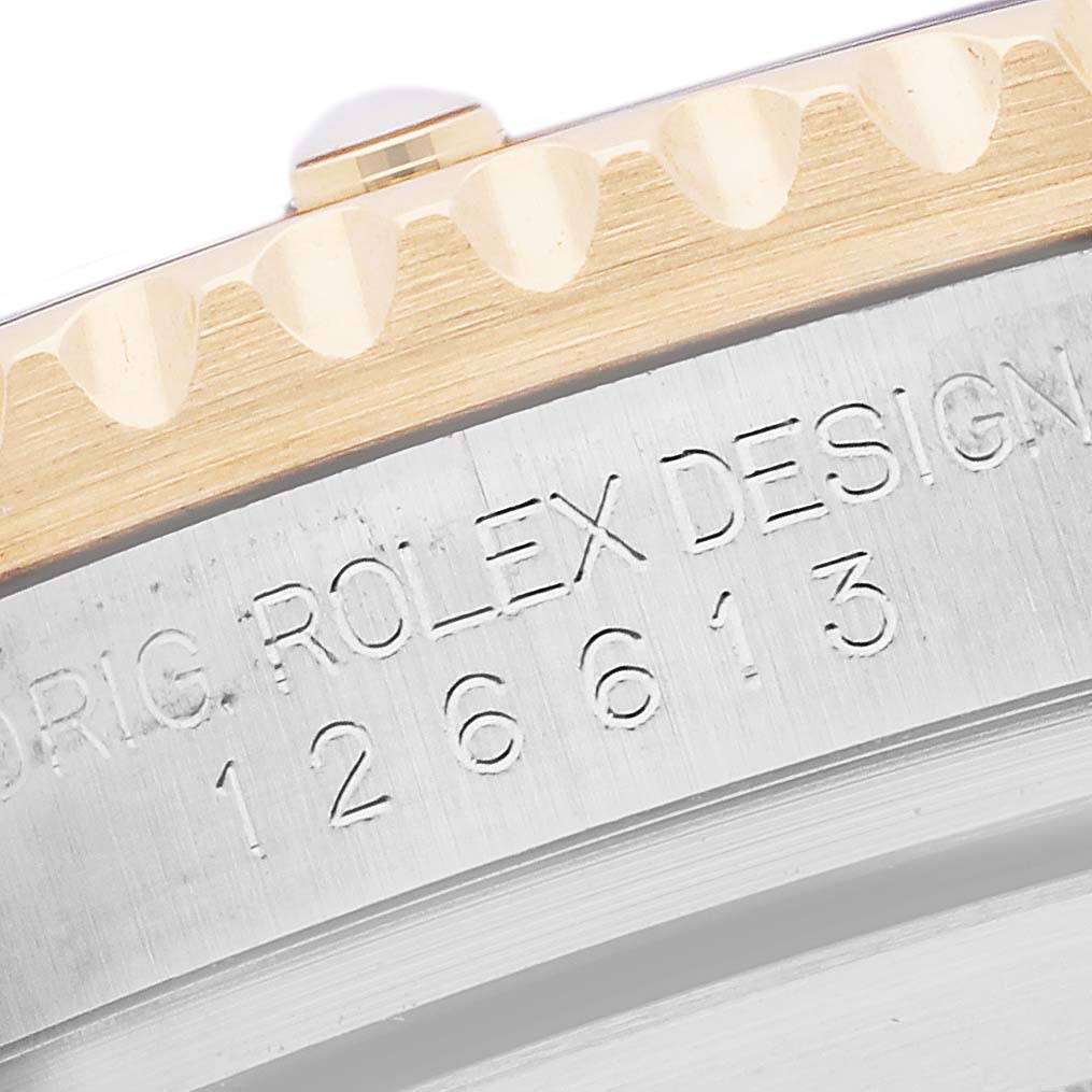 The image shows a close-up of the side of a Rolex Submariner 126613LN Men's Steel and Gold (two tone) Black Dial 126613LN Men's Steel and Gold (two tone) Black Dial's bezel and edge, highlighting the engraving.
