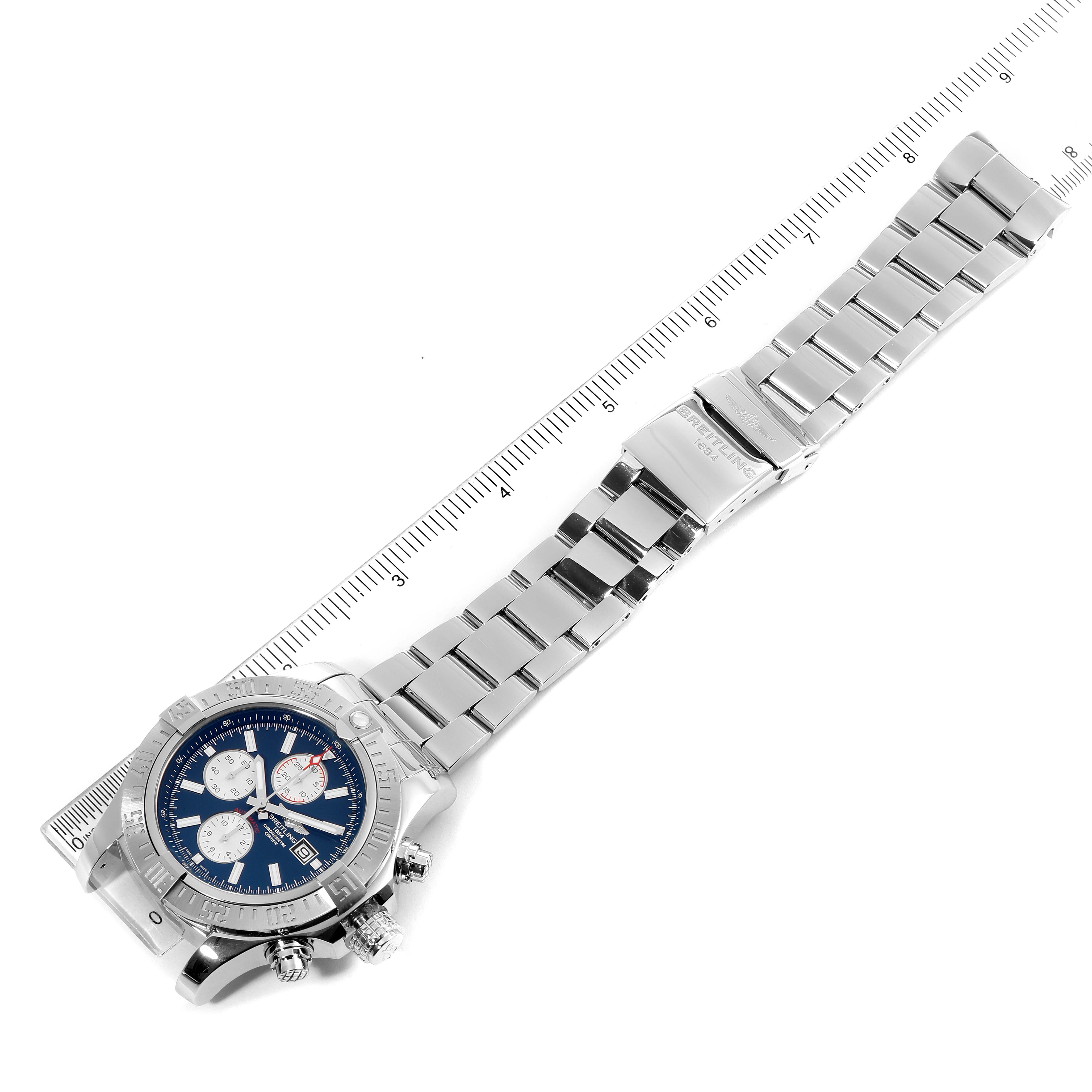 The image shows an aerial view of a Breitling Avenger A13371 Men
s Stainless Steel Blue Dial A13371 Men
s Stainless Steel Blue Dial watch with a metal bracelet and a ruler for scale.