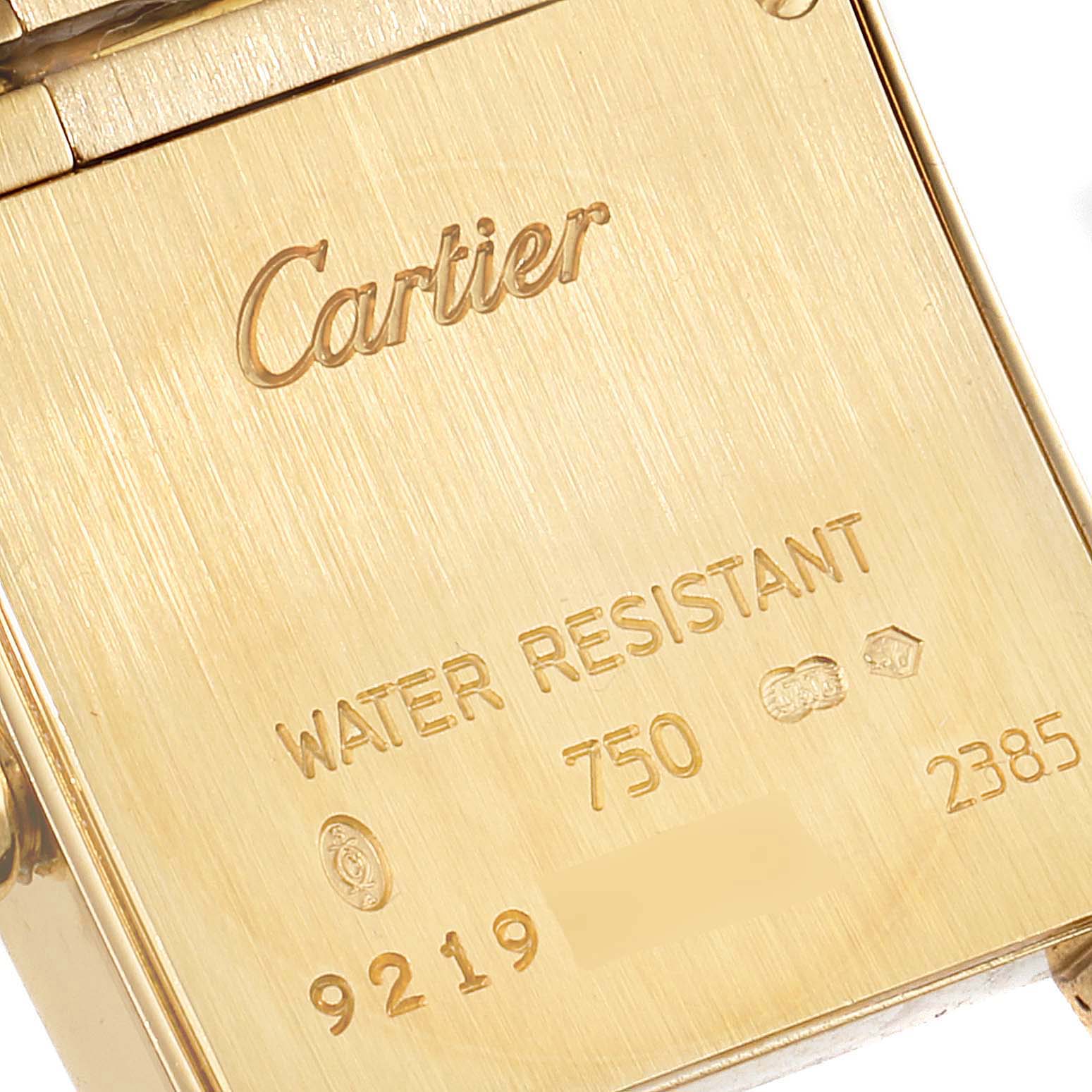 The image shows the back of the Cartier Tank Francaise W50002N2 Women
s Yellow Gold Silver Dial W50002N2 Women
s Yellow Gold Silver Dial watch, displaying its engravings and markings.
