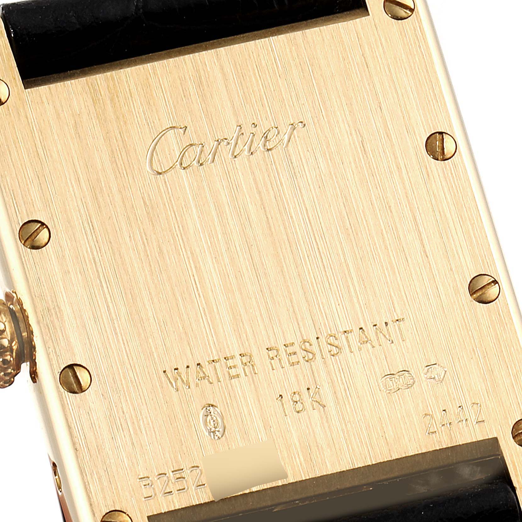 The image shows the back case of a Cartier Tank Louis W1529856 Women
s Yellow Gold Silver Dial W1529856 Women
s Yellow Gold Silver Dial watch, displaying engravings and screws.