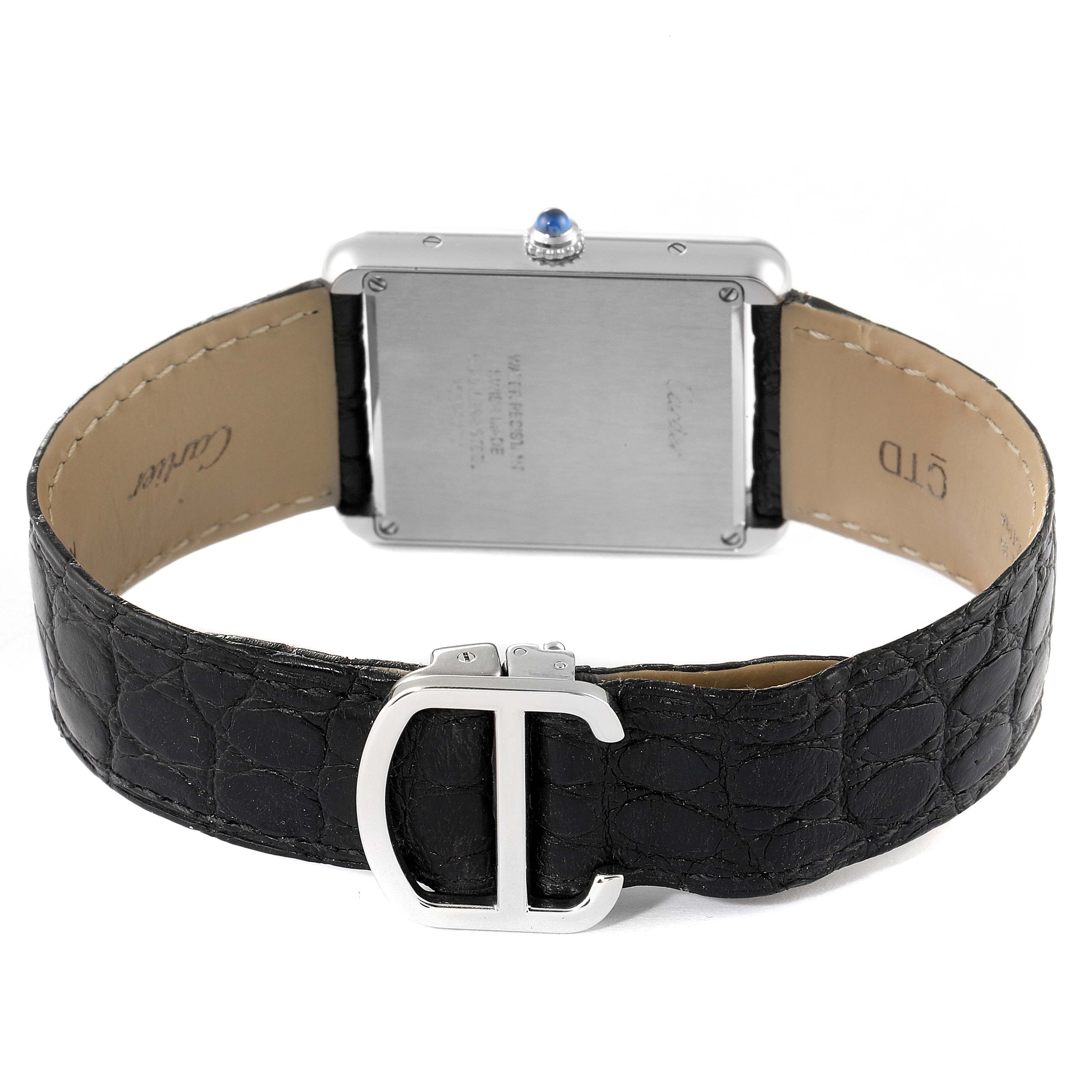 This image shows the back of a Cartier Tank Solo W1018355 Men's Stainless Steel Silver Dial W1018355 Men's Stainless Steel Silver Dial watch and a partial view of its black leather strap with the buckle.