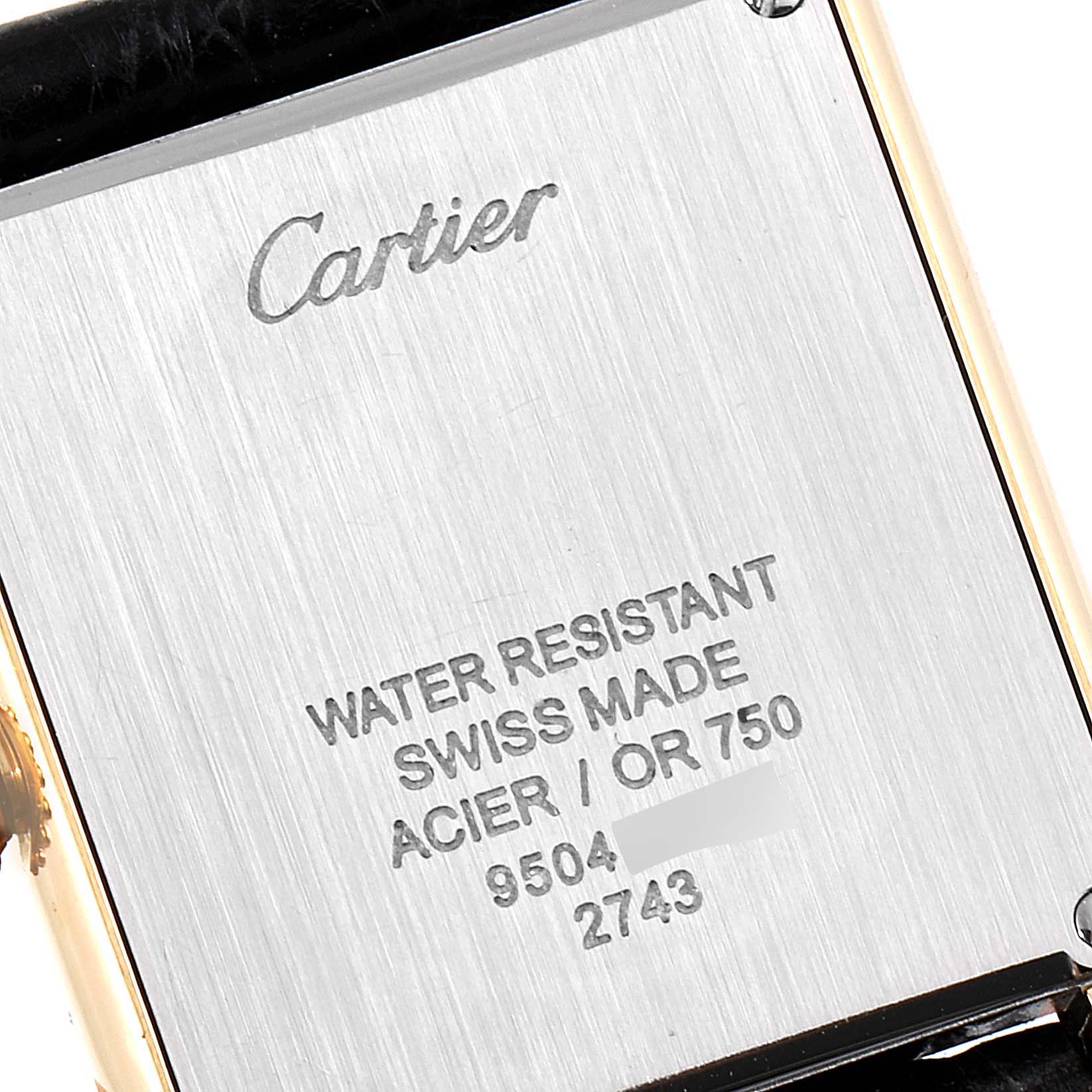 This is a close-up shot of the back case of the Cartier Tank Solo W1018755 Women
s Steel and Gold (two tone) Silver Dial W1018755 Women
s Steel and Gold (two tone) Silver Dial watch, showing its inscriptions and material details.