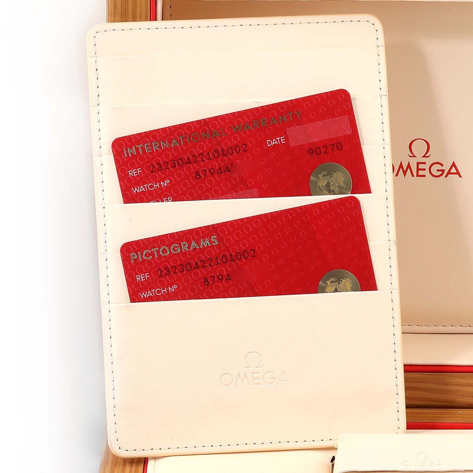 The image shows the warranty cards and holder for an Omega Planet Ocean 232.30.42.21.01.002 Men
s Stainless Steel Black Dial 232.30.42.21.01.002 Men
s Stainless Steel Black Dial watch.