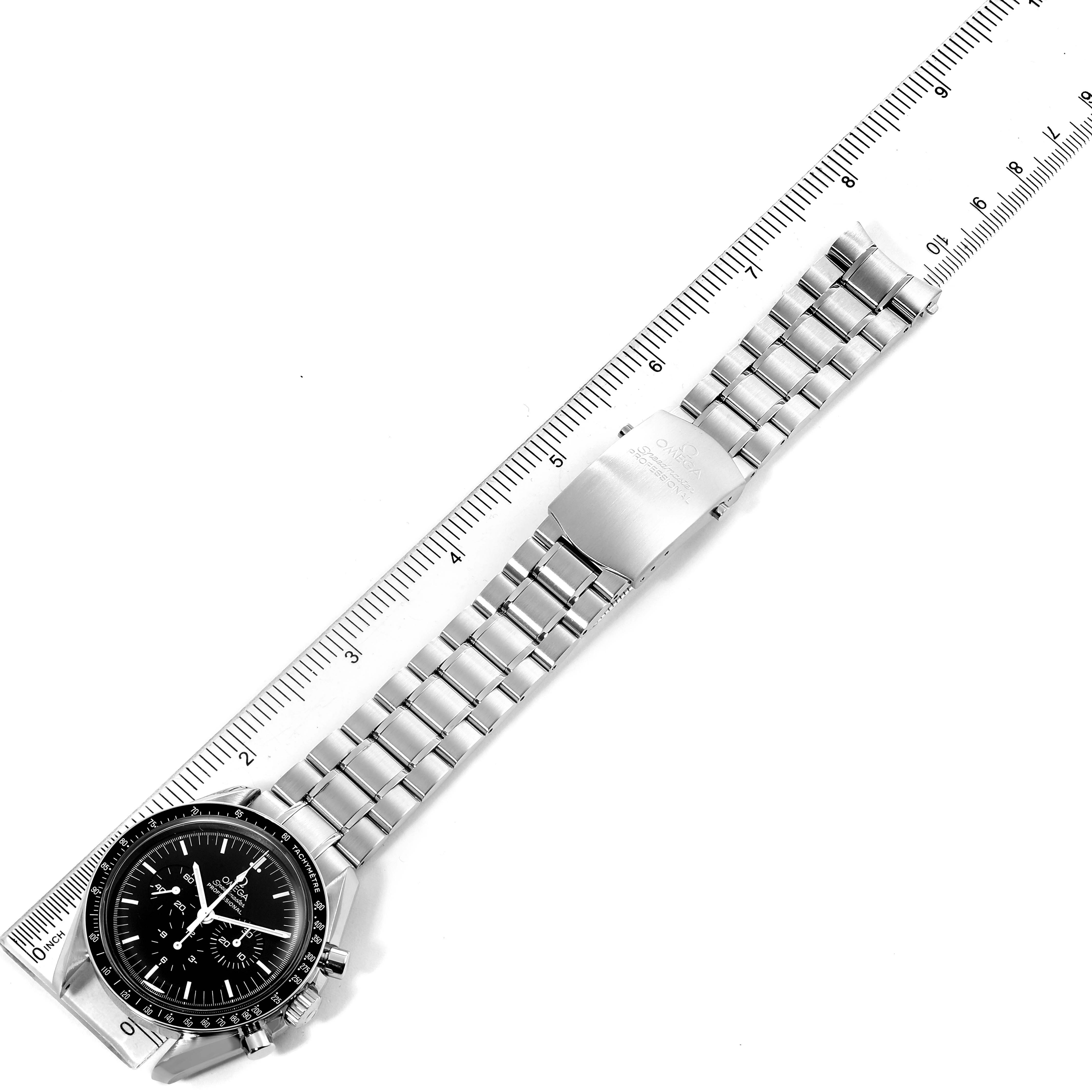 The Omega Speedmaster 3570.50.00 Men
s Stainless Steel Black Dial 3570.50.00 Men
s Stainless Steel Black Dial watch is displayed flat with its face and metal bracelet visible, alongside a ruler for measurement.