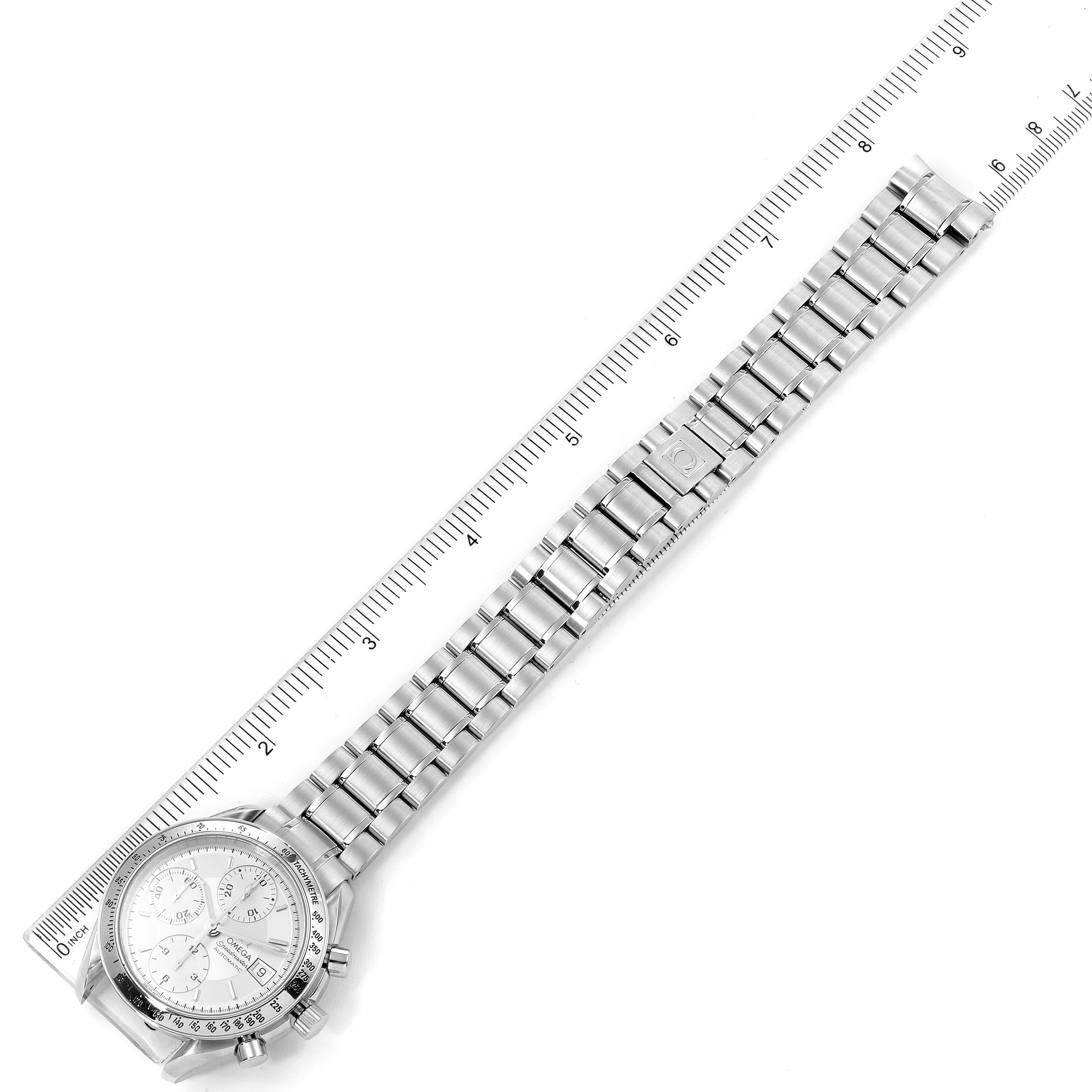 The Omega Speedmaster 3513.30.00 Men
s Stainless Steel Silver Dial 3513.30.00 Men
s Stainless Steel Silver Dial watch is shown from a top-down angle, displaying its face and full metal bracelet laid out with a ruler.