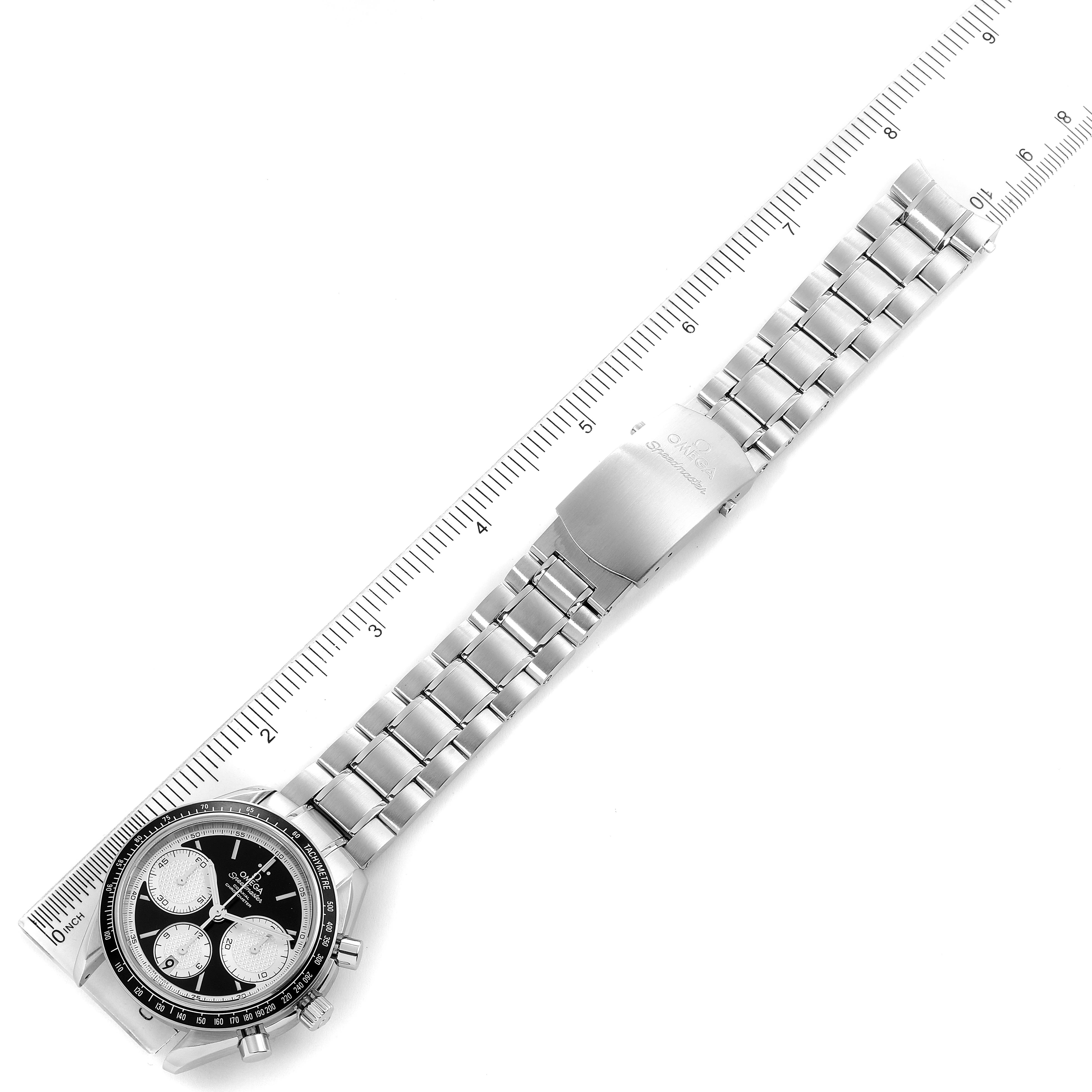 The image shows an overhead view of an Omega Speedmaster 326.30.40.50.01.002 Men
s Stainless Steel Black Dial 326.30.40.50.01.002 Men
s Stainless Steel Black Dial watch, highlighting its face, bezel, and metal bracelet alongside a ruler.