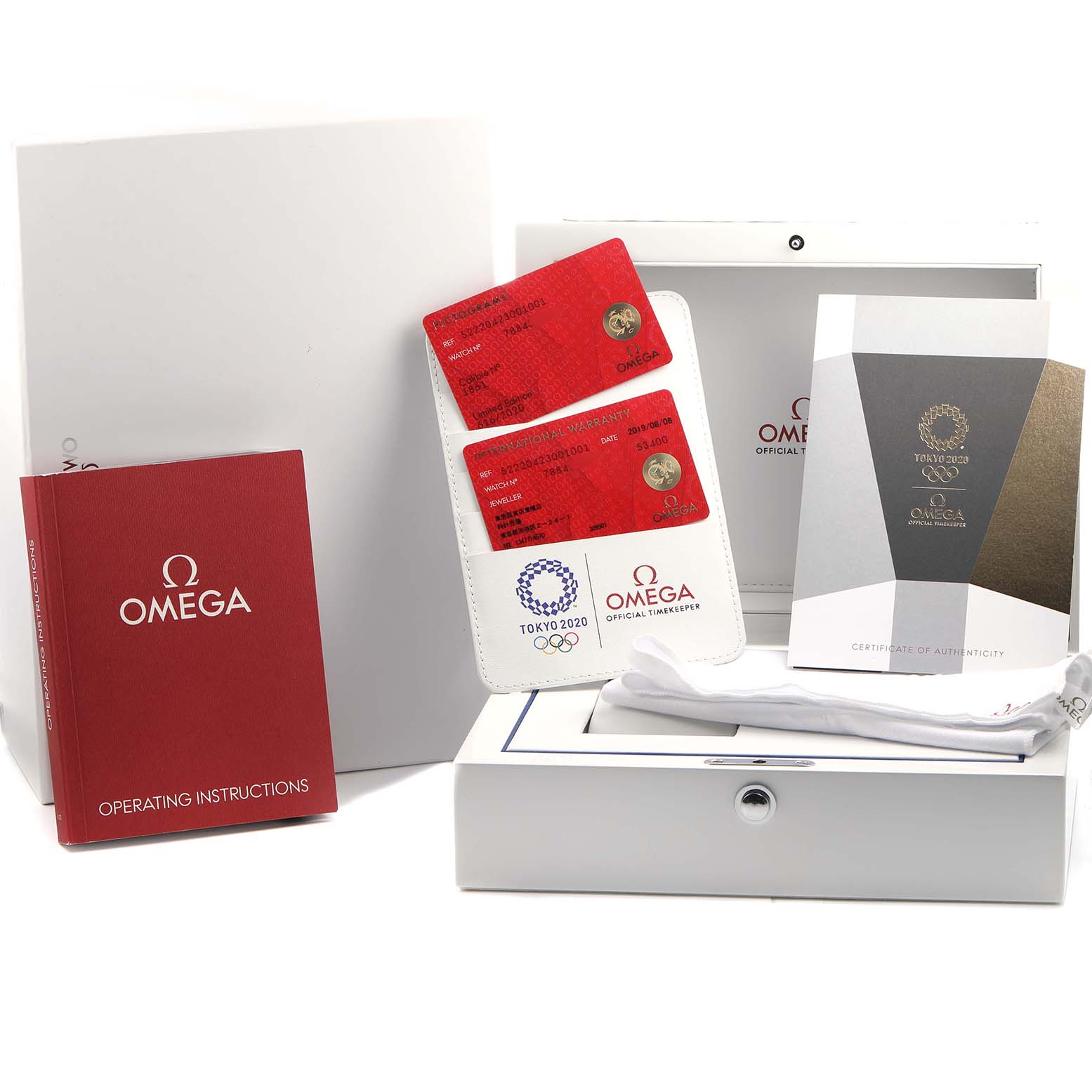 The image shows Omega Speedmaster 522.20.42.30.01.001 Men's Stainless Steel Black Dial accessories, including red cards, manuals, and a white box, viewed from above.