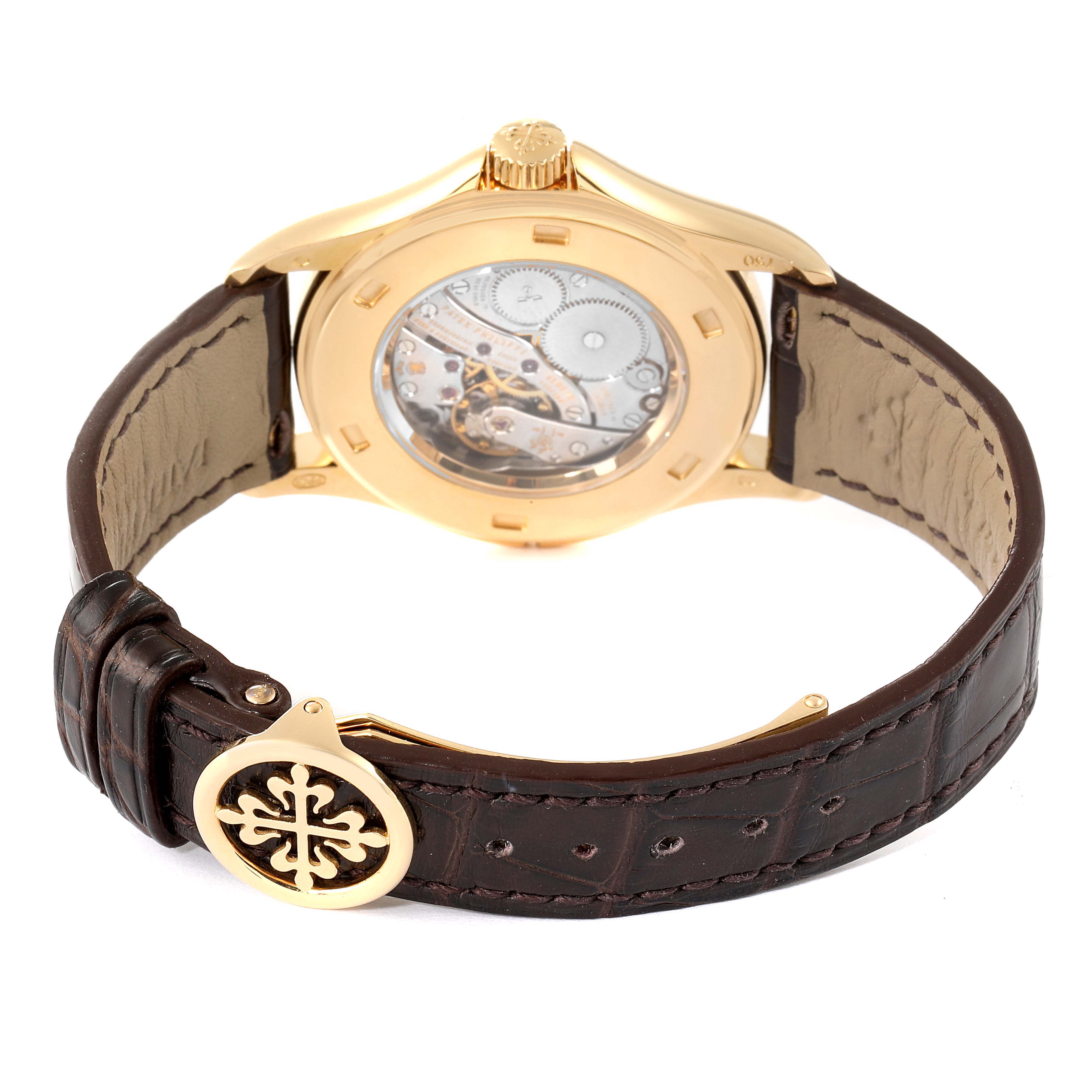 The image shows the back view of a Patek Philippe Calatrava 5134J Men
s Yellow Gold White Dial 5134J Men
s Yellow Gold White Dial watch, highlighting its open case back and leather strap.