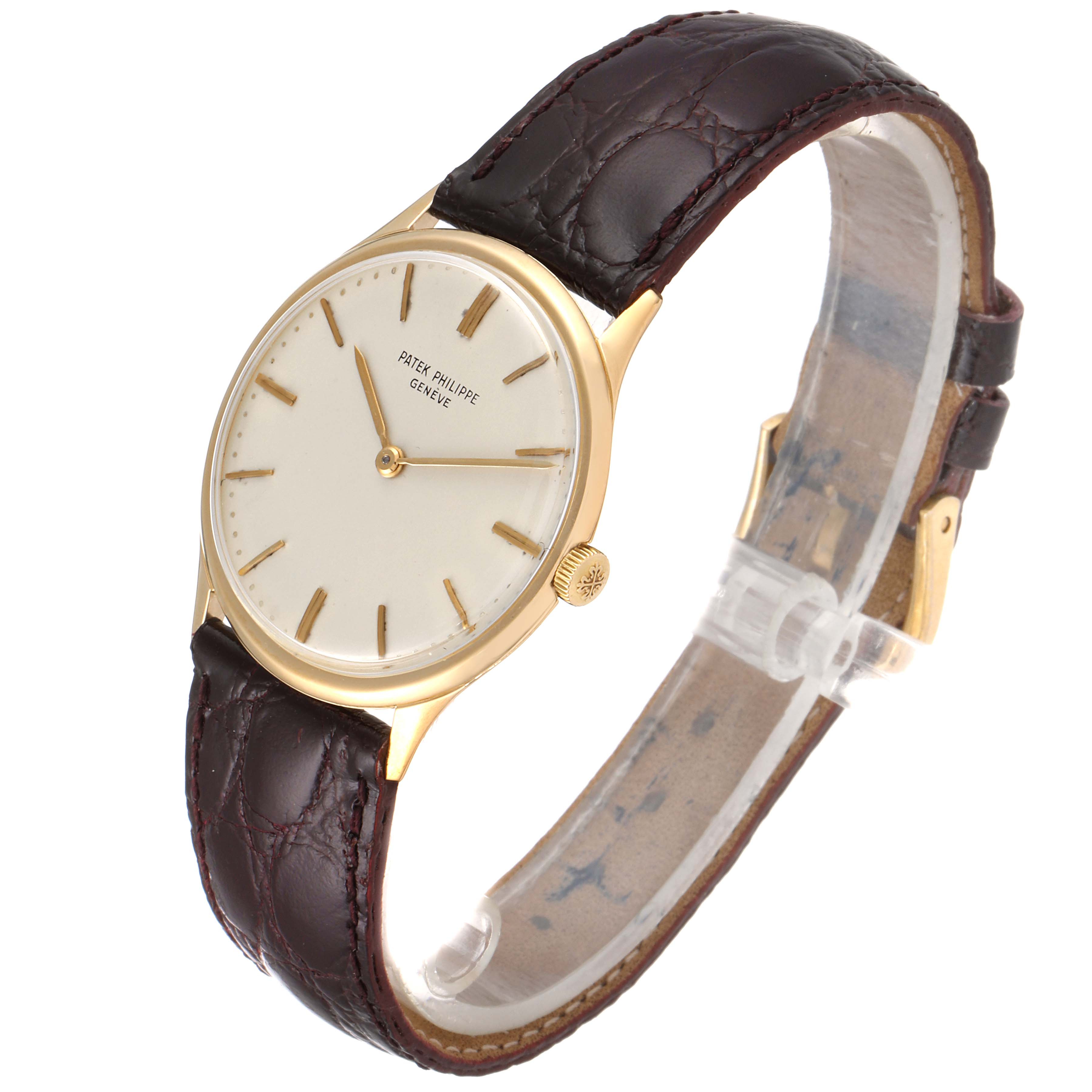 The image shows a side angle of the Patek Philippe Vintage model watch, featuring its golden case, white dial, and brown leather strap.