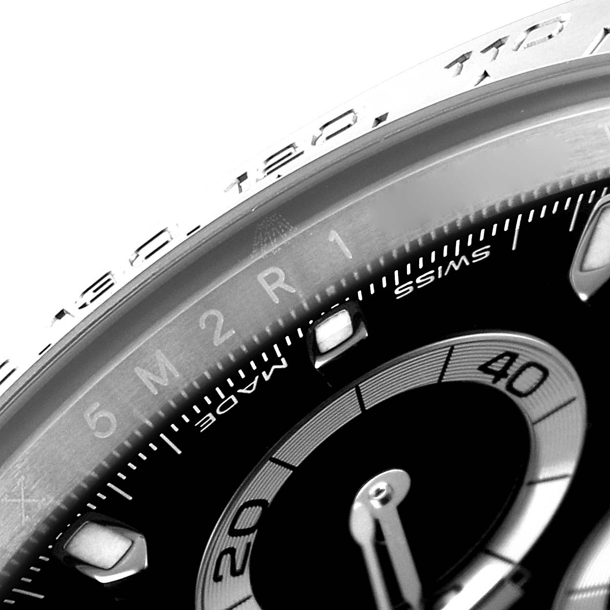 This close-up image of a Rolex Daytona 116500 Men's Stainless Steel Black Dial 116500 Men's Stainless Steel Black Dial shows part of the dial and bezel from an angled perspective.