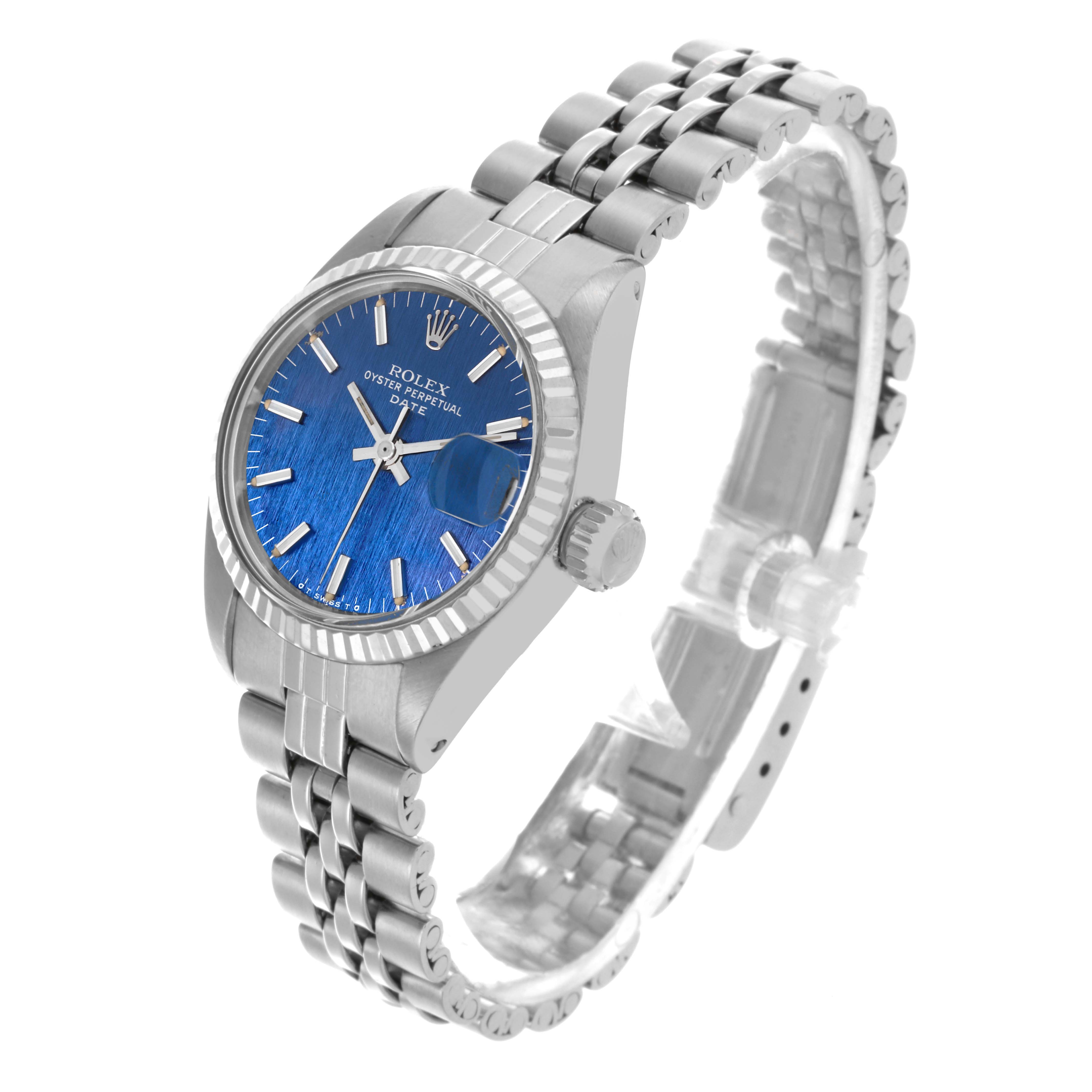 The Rolex Date 6917 Women's Stainless Steel Blue Dial 6917 Women's Stainless Steel Blue Dial watch is shown from an angled view highlighting its blue dial, fluted bezel, case, crown, and bracelet.