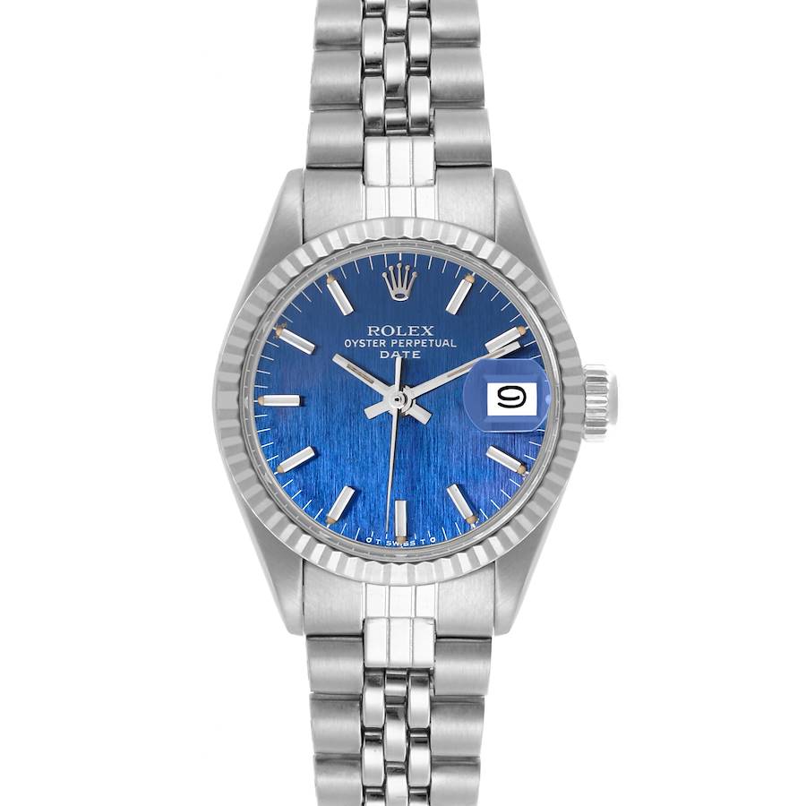 The Rolex Date model watch is shown from the front, displaying its blue dial, date window, and metal bracelet.