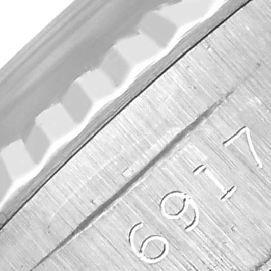 The image shows a close-up view of the engraved serial numbers and fluted bezel of a Rolex Date 6917 Women's Stainless Steel Blue Dial 6917 Women's Stainless Steel Blue Dial watch.
