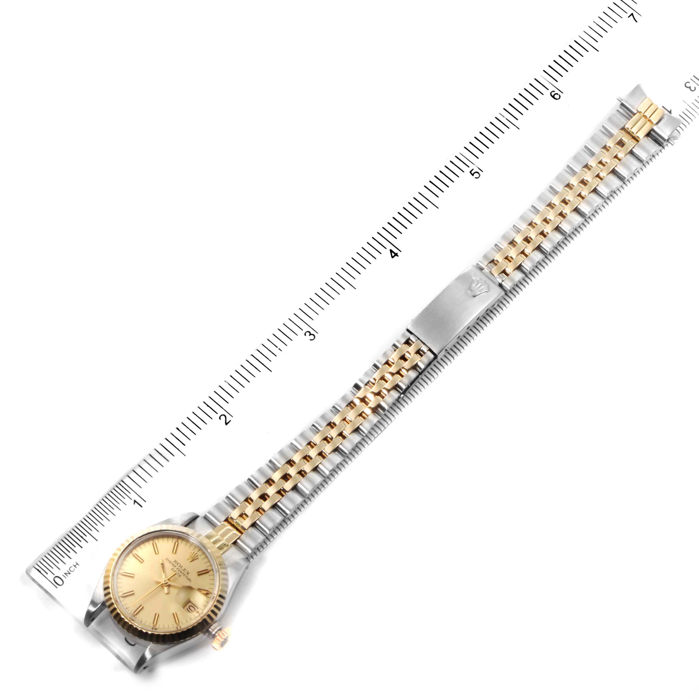The image shows a Rolex Date 6917 Women's Steel and Gold (two tone) Champagne Dial 6917 Women's Steel and Gold (two tone) Champagne Dial model watch, including its face and full metal bracelet with a ruler for size reference.