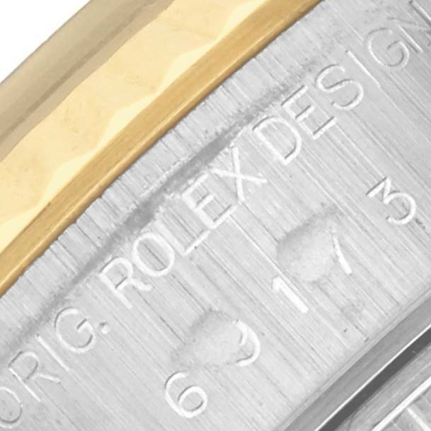 The image shows a close-up of the side case engraving and bezel of a Rolex Datejust 69173 Women's Steel and Gold (two tone) White Dial 69173 Women's Steel and Gold (two tone) White Dial watch.
